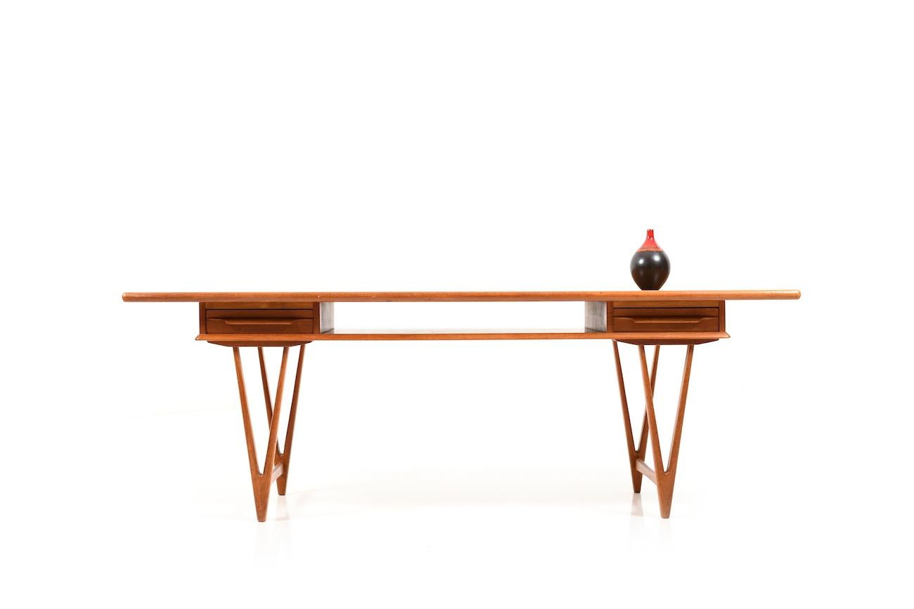Midcentury Danish rectangular teak wooden sofa table. Below the tabletop with two drawers which can be opened on both sides. Very nice designed legs in V-shape. Design by E.W Bach for Toften Møbelfabrik, early 1960s.
