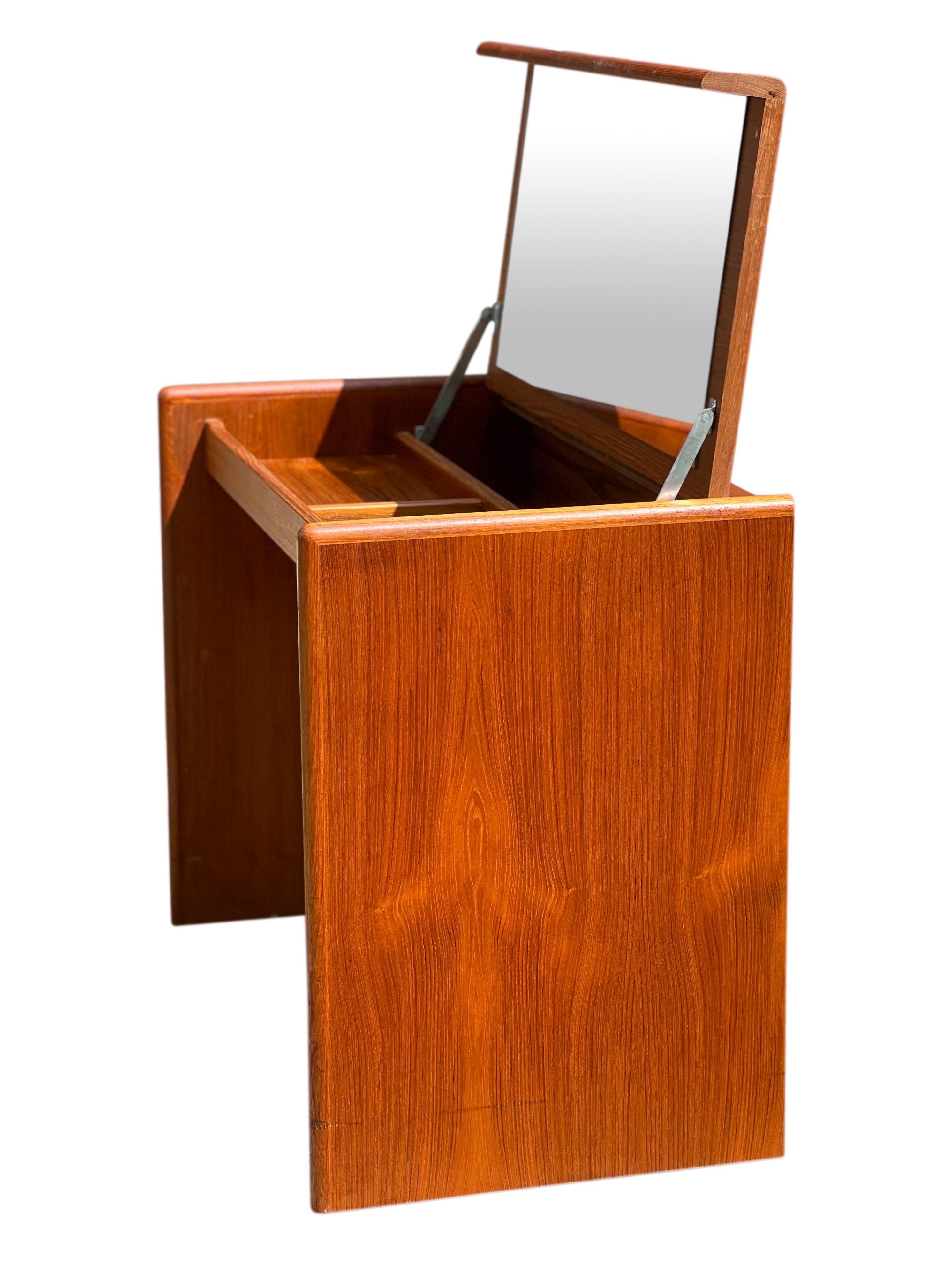 Fabulous mid-century Danish teak Vanity with flip open top.

The vanity features a full piano hinge and a fantastic large, high quality mirror. Very sturdy and well-crafted, the vanity offers lots of useful, categorized storage space in pristine