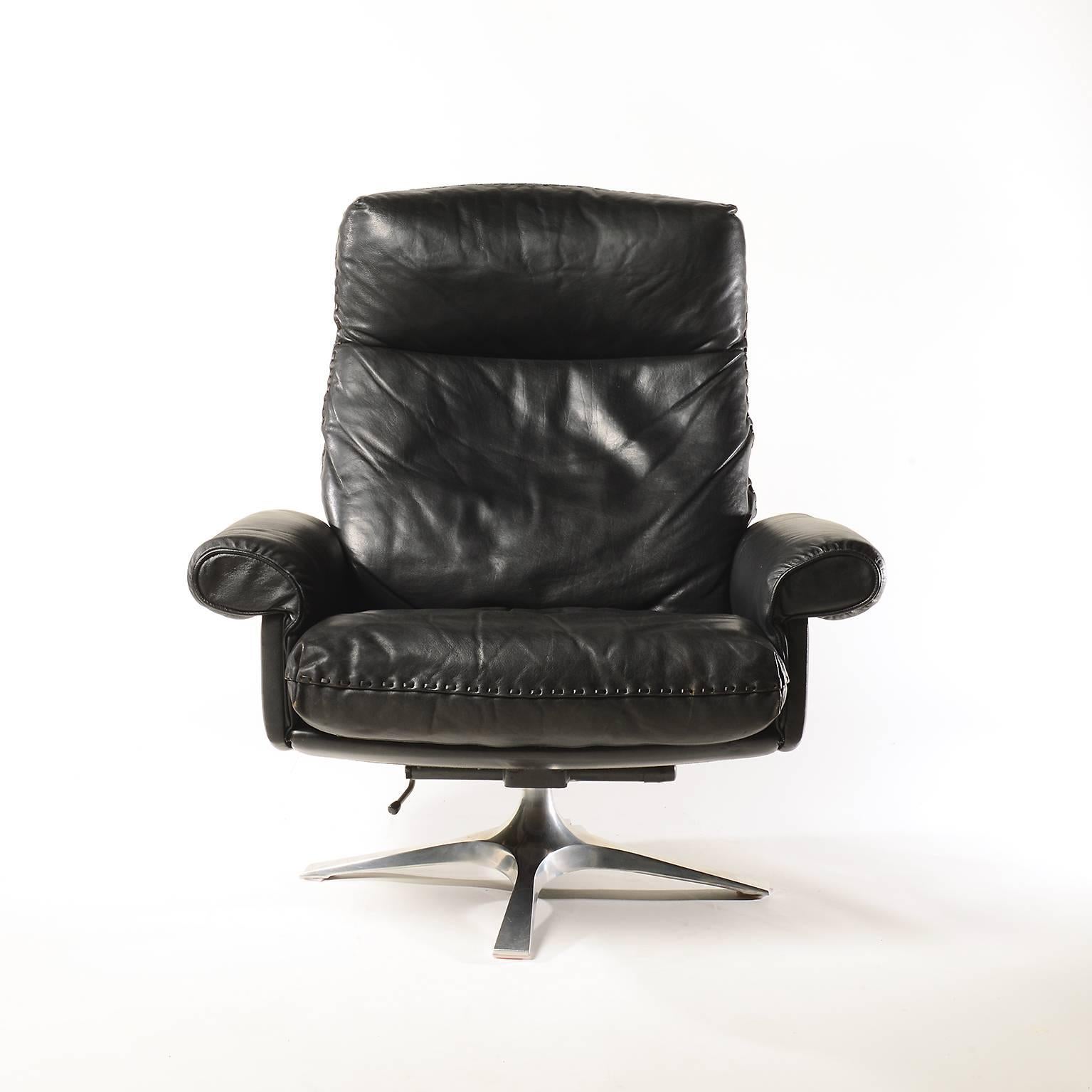 Midcentury De Sede DS 31 high-back swivel lounge armchair with ottoman, 1970
The chair was made in the 1970s by De Sede in Switzerland.
The armchair and ottoman sit on a polished swivel chrome plated base and are upholstered in black leather with
