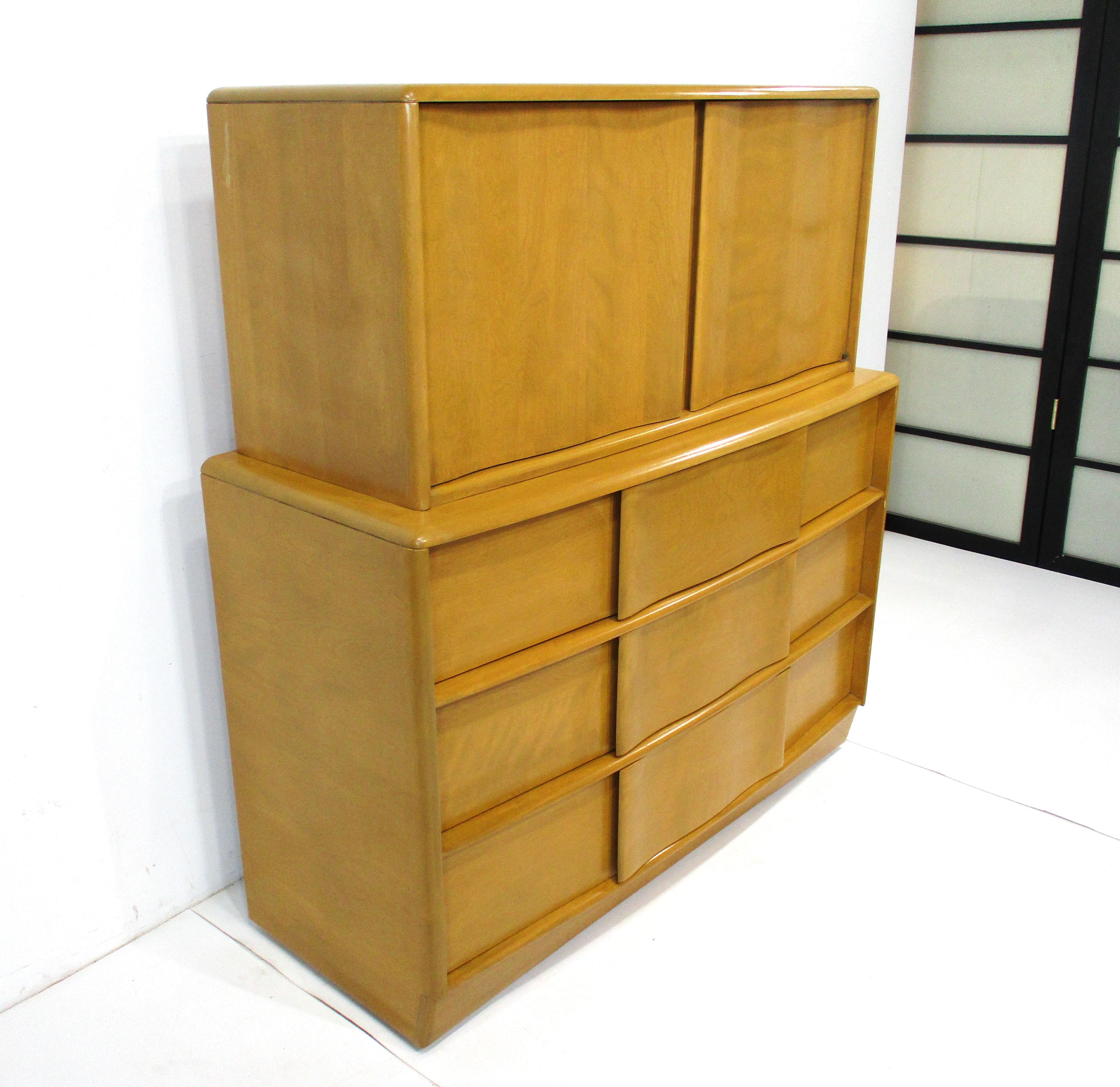 A rare two-piece sculptural front deck top dresser chest on chest in solid maple wood with upper storage having two doors and fixed shelves. The lower dresser has three drawers and provides plenty of storage, from the desirable Sculptura Collection