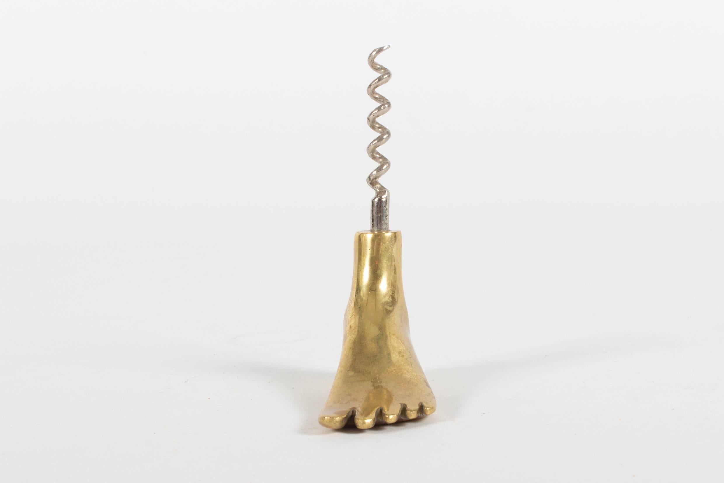 A humorous and well-shaped bar accessory by the infamous designer Carl Auböck who is best known for his designs of everyday objects. Made from brass and steel, some of these foot corkscrews were sold with a bamboo lid, the presented one comes