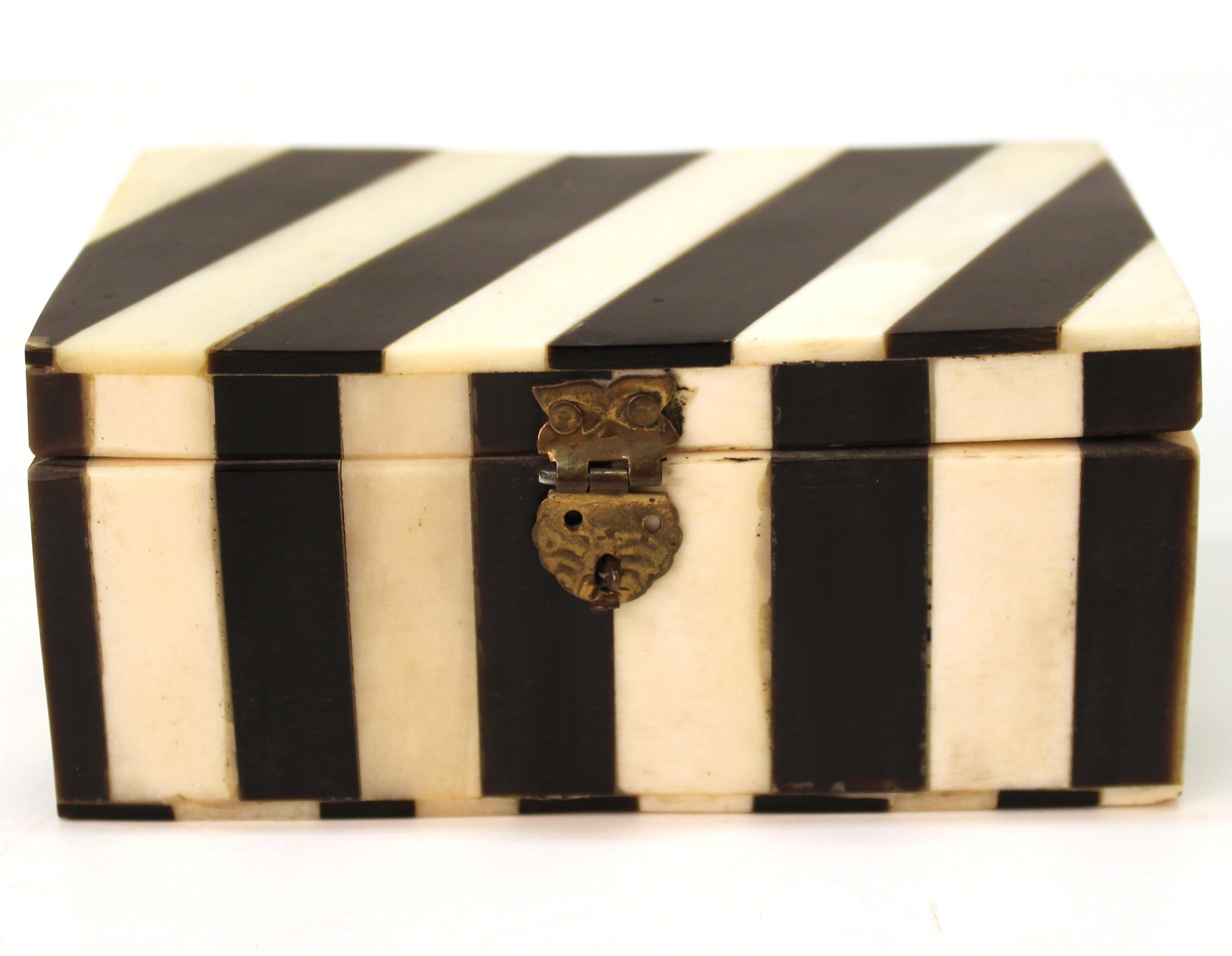 Midcentury decorative small trinket box with an outside striped surface made of white and black bone. The interior has a black lining. The piece is in good vintage condition with age-appropriate wear.