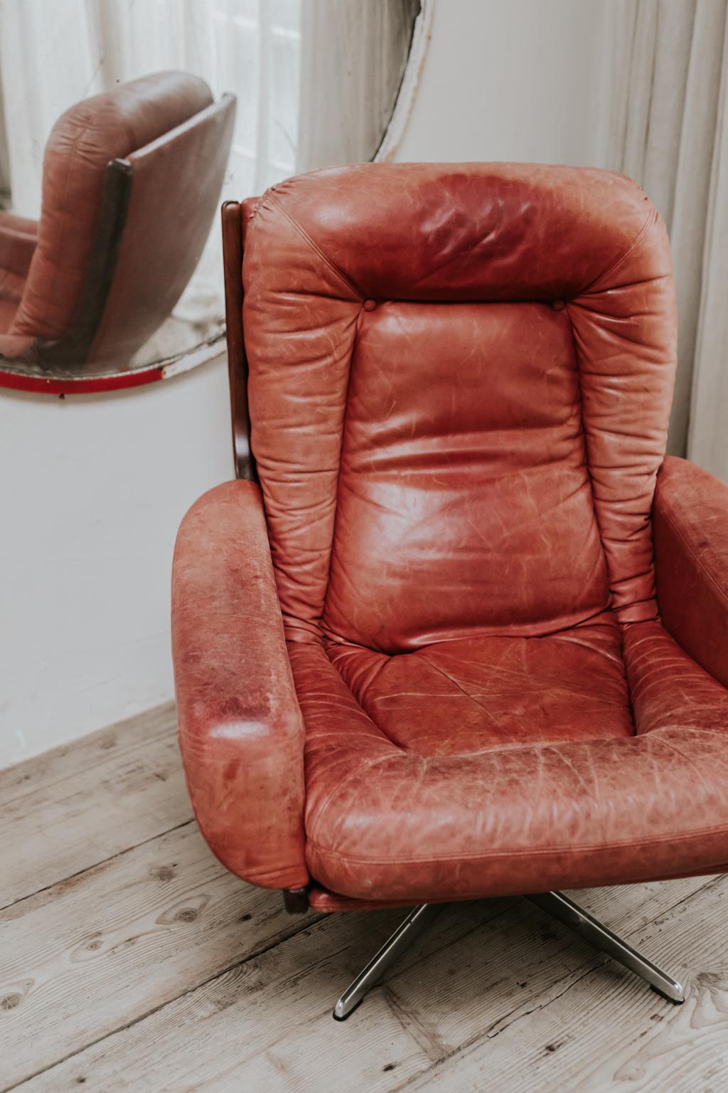 A warm patined red leather 1970s swivel armchair, very comfortable and in good condition.