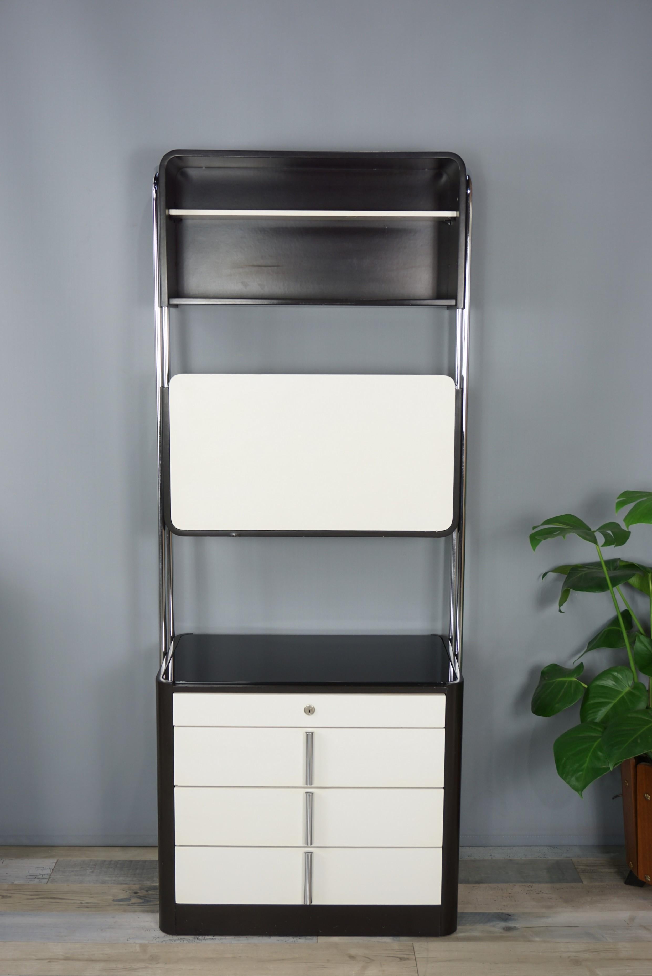 Storage cabinet 60 - 70 years in black and white resin on a tubular chrome structure. Design, aerial and graphic it consists of a dresser 4 drawers with chrome handles, black glass top, a closable storage space with flap and a top box. The bar
