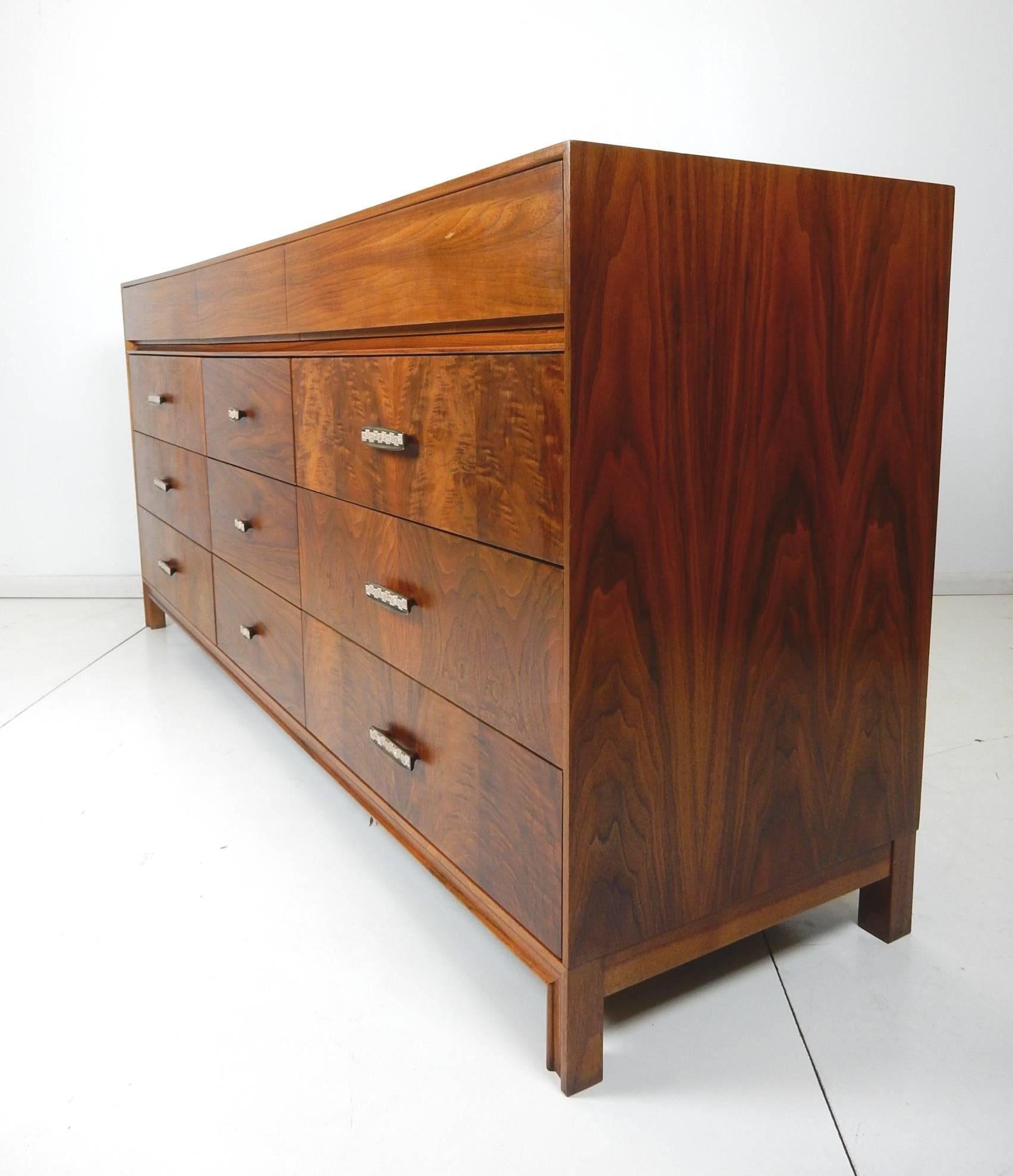 Gorgeous, finely crafted chest of drawers designed by John Keal for Brown-Saltman in the early 1950s.
An astonishing linear design that is beyond captivating. The two-tone wood used has an amazing grain pattern on front, top and sides.
Nine