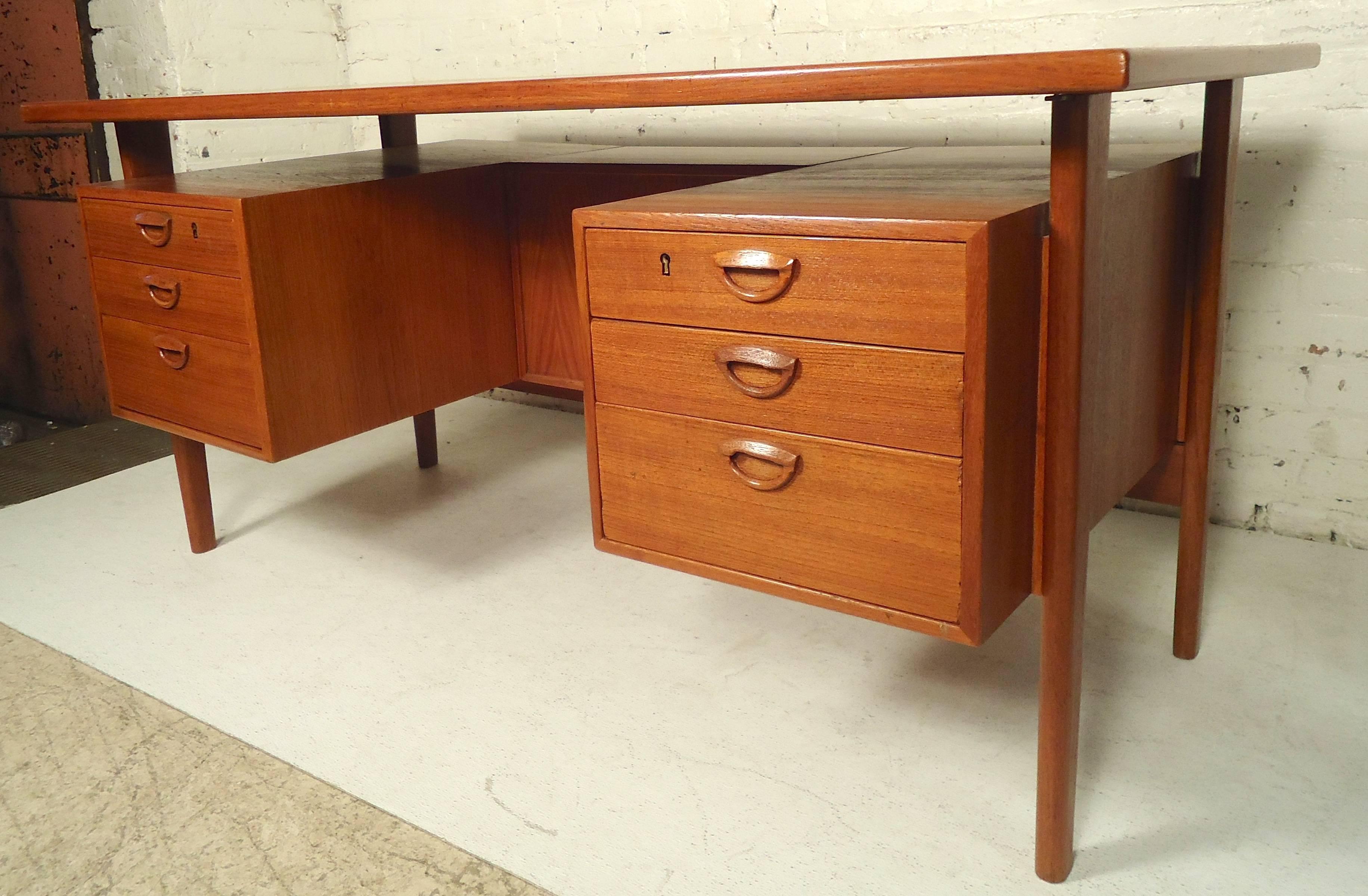 Teak Danish desk with floating top. Six drawers with sculpted handles, tapered legs and finished back with open storage.

(Please confirm item location - NY or NJ - with dealer).
 