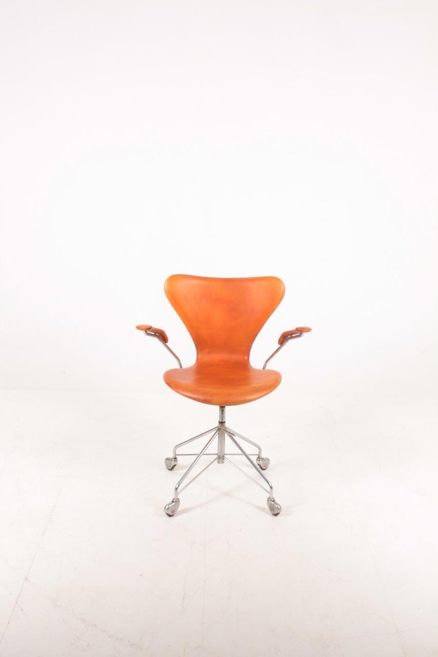 Swivel chair in patinated leather designed by Arne Jacobsen for Fritz Hansen. Made in Denmark. Great condition.