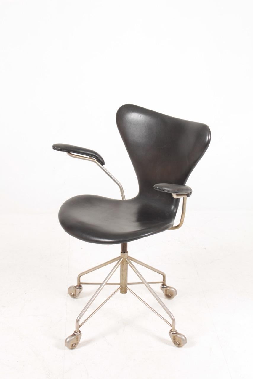 Swivel chair in patinated leather designed by Arne Jacobsen for Fritz Hansen. Made in Denmark. Great condition.