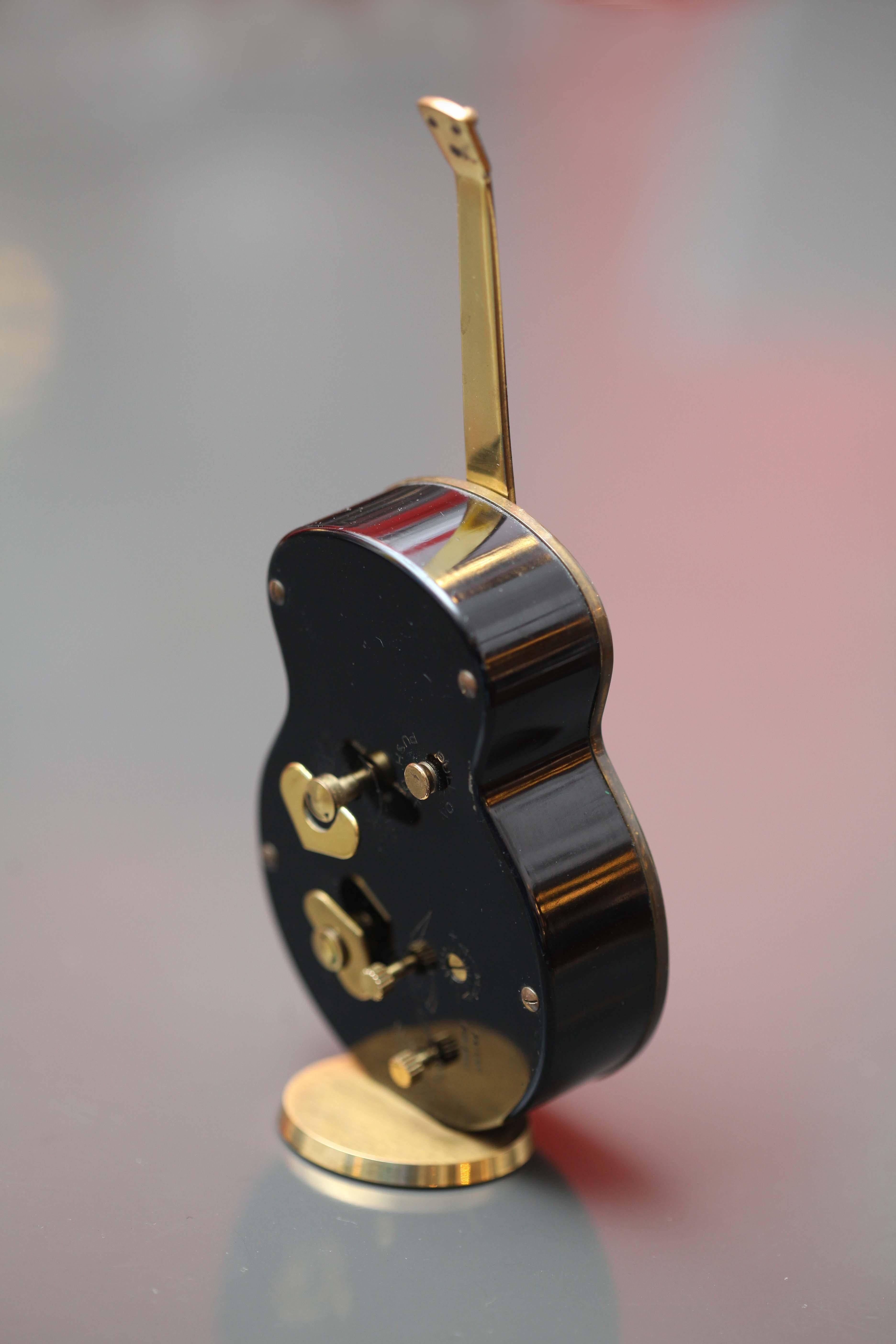 Midcentury desk clock
in shape of a guitar
8 days movement with mechanism alarm melody
Switzerland, 1950.