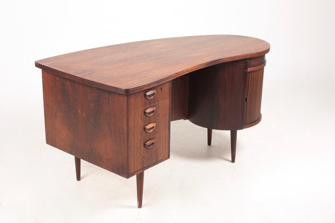 Great looking freestanding desk in rosewood with a bank of four drawers and a roll front dry bar section. Designed by Kai Kristiansen M.A.A. for FM Furniture, Denmark in 1950s. Original condition.