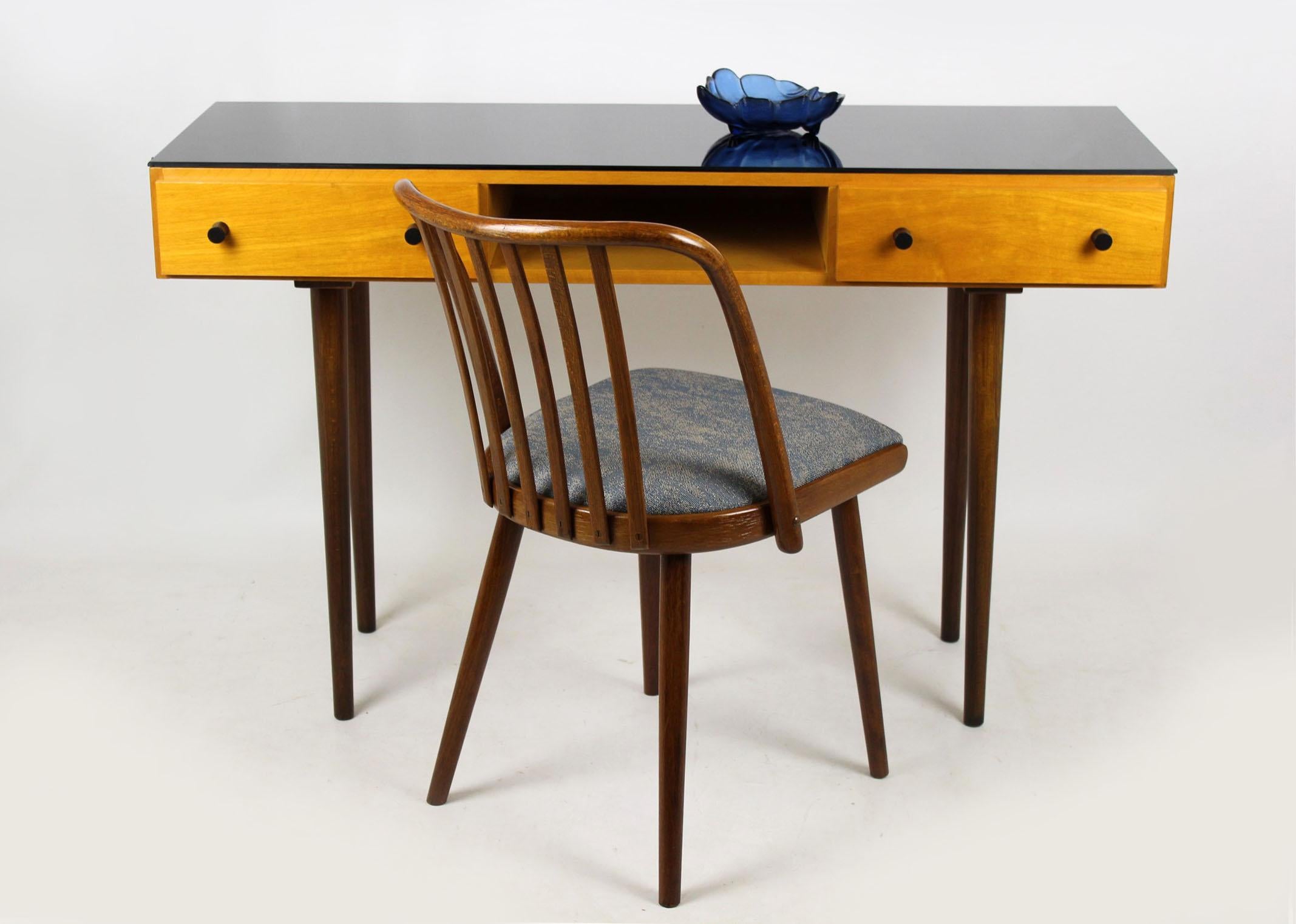 Midcentury small desk which can also be used as a console table. Designed by Mojmír Požár in 1957 and manufactured by UP Bucovice in former Czechoslovakia during the 1960s. Features two drawers, retains its original black glass on the top. Woodwork