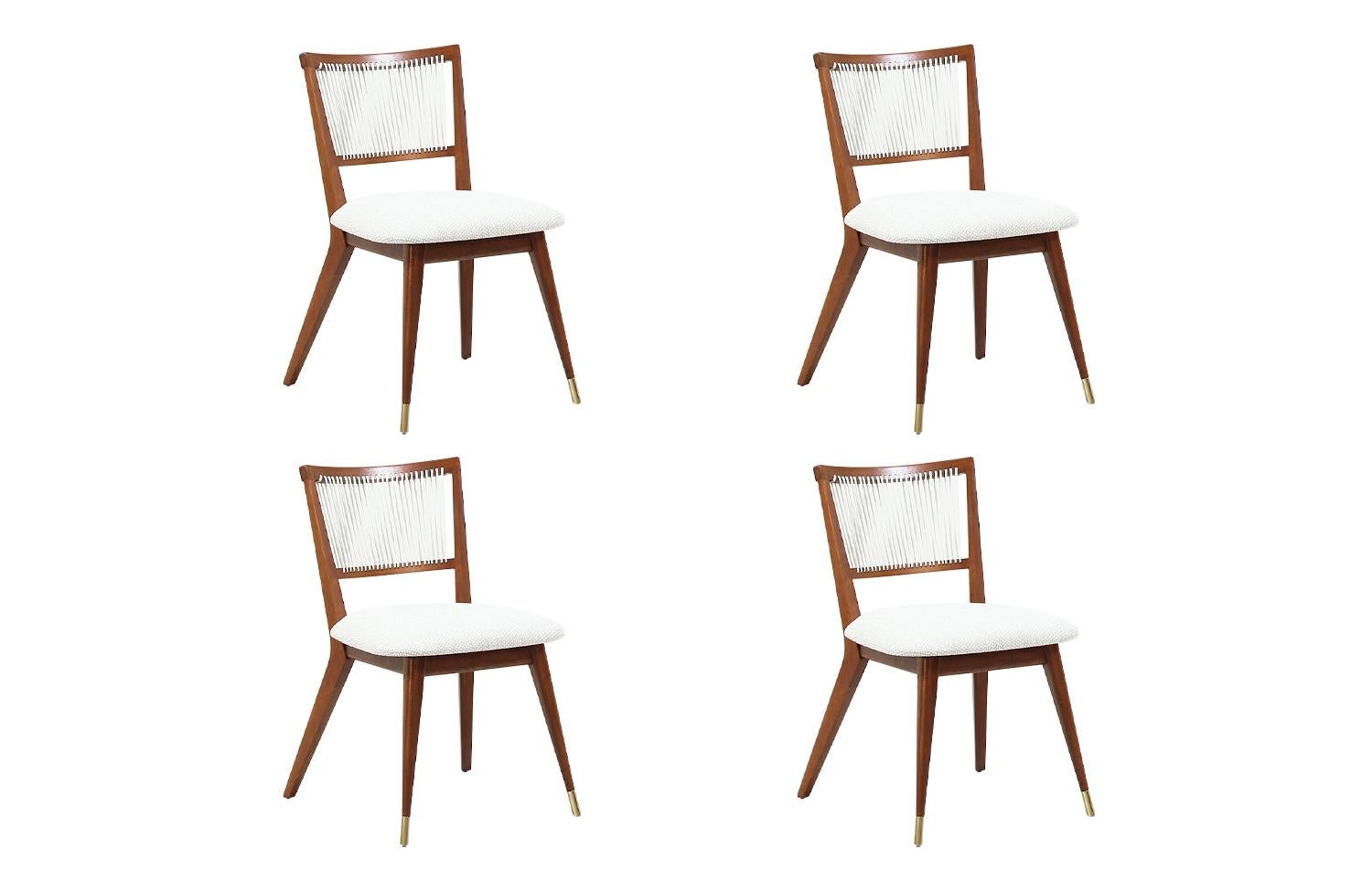 Set of four Mid-Century Modern dining chairs designed by John Keal for Brown Saltman in the United States, circa 1960s. These newly refinished chairs feature a sturdy walnut wood frame with brass sabots at the front legs and new light tweed fabric