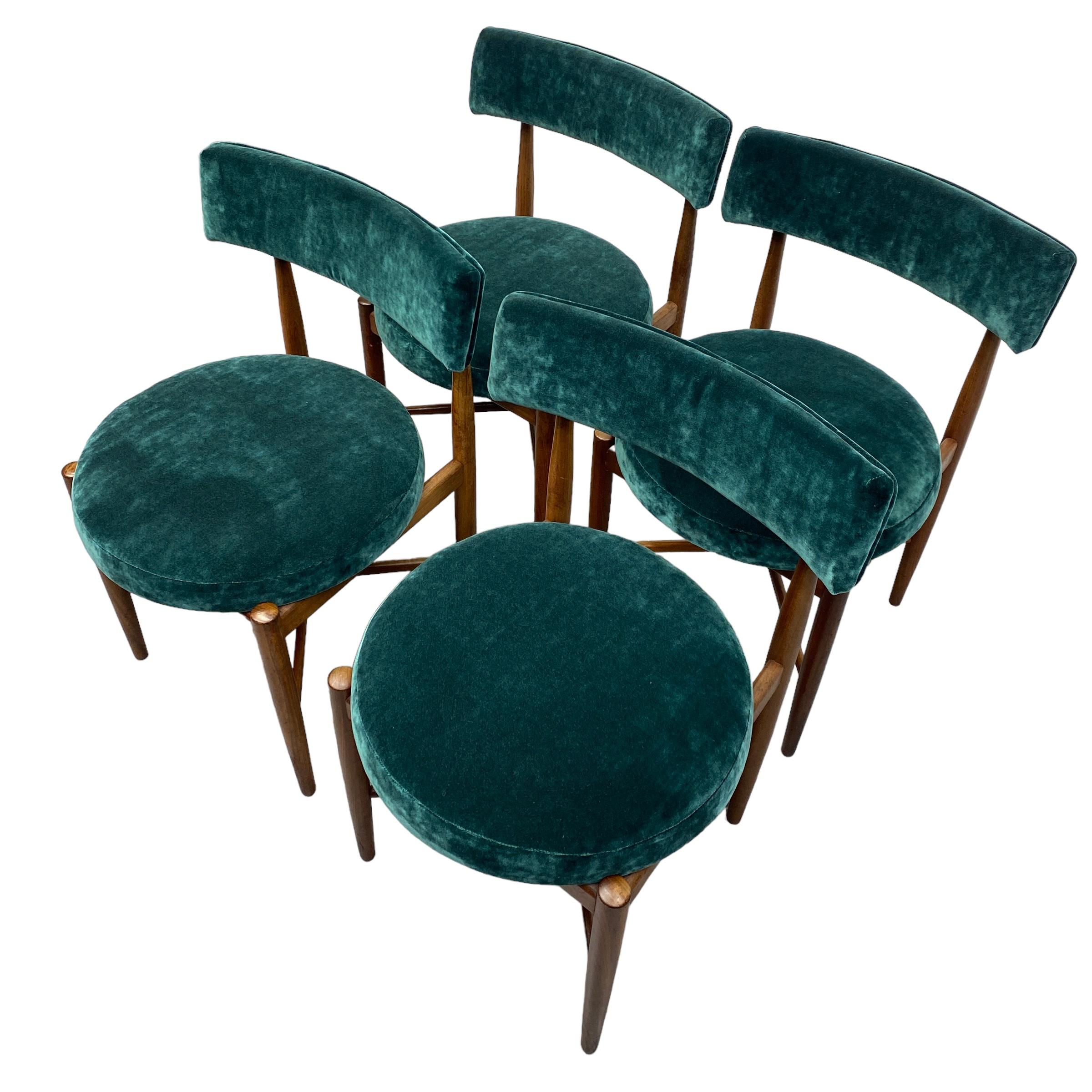 A set of four mid century Danish inspired Kofod Larsen for G Plan dining chairs. The dining chair legs & frame are in beautiful teak. The back rest & seats are professionally reupholstered in emerald green velvet. The dining chairs are very stylish