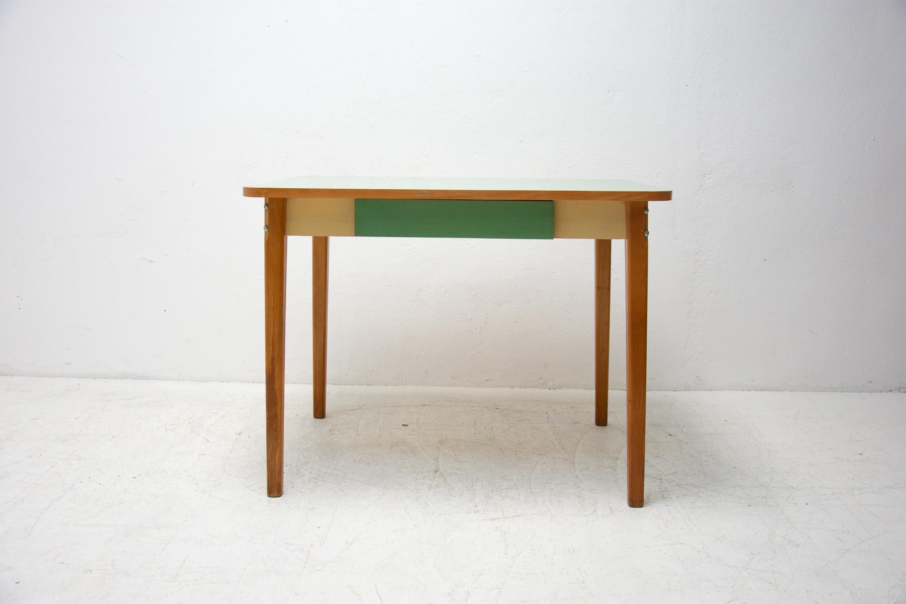 Mid century dining table with a formica plate, beech legs and one drawer. It was made in the former Czechoslovakia in the 1960´s. In very good vintage condition.