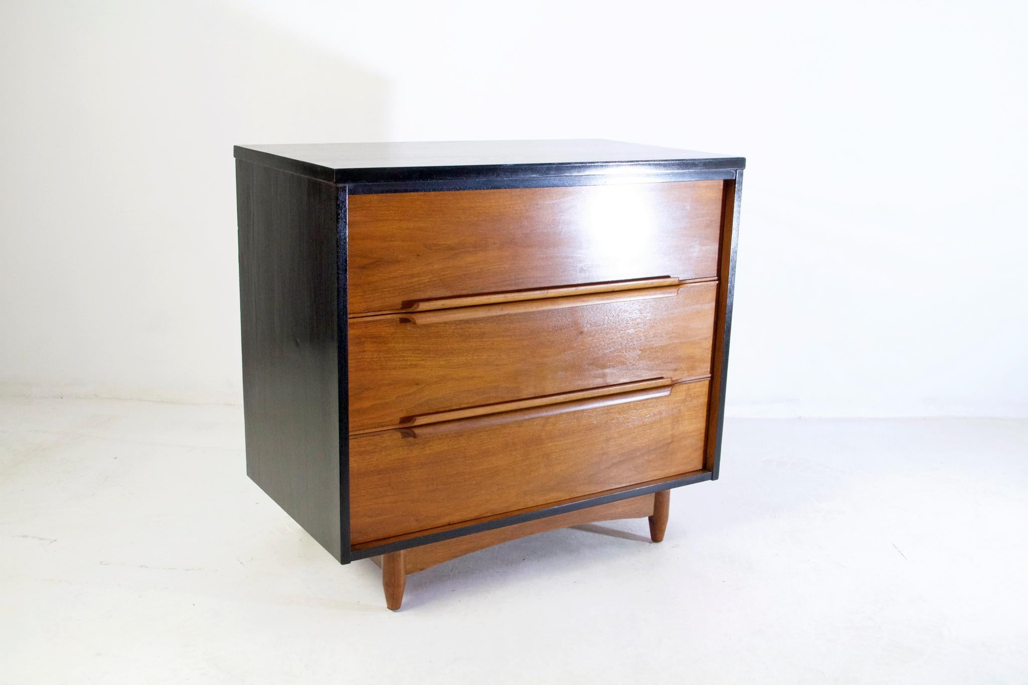 An elegant dresser in teak with an ebonized frame. It has four spacious drawers with handles that are incorporated curved handles. In very nice restored condition and of high quality production.