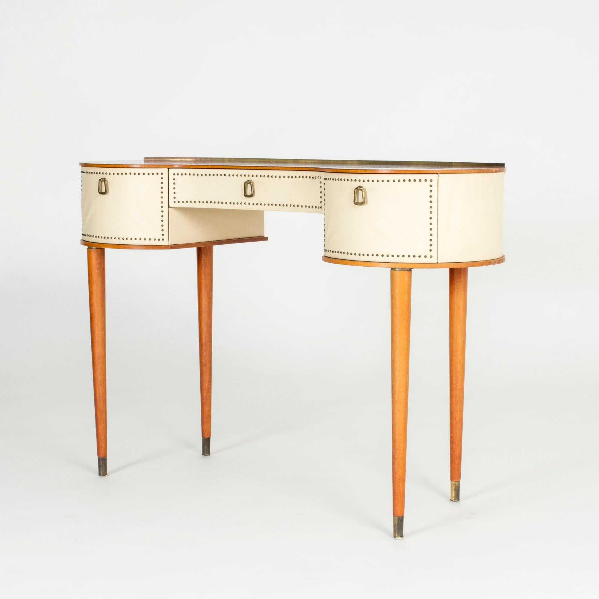 Neat dressing table by Halvdan Pettersson, with an organic teak tabletop framed by an elegant brass rim. Sides dressed in white faux leather and decorated with brass nails. Brass feet.