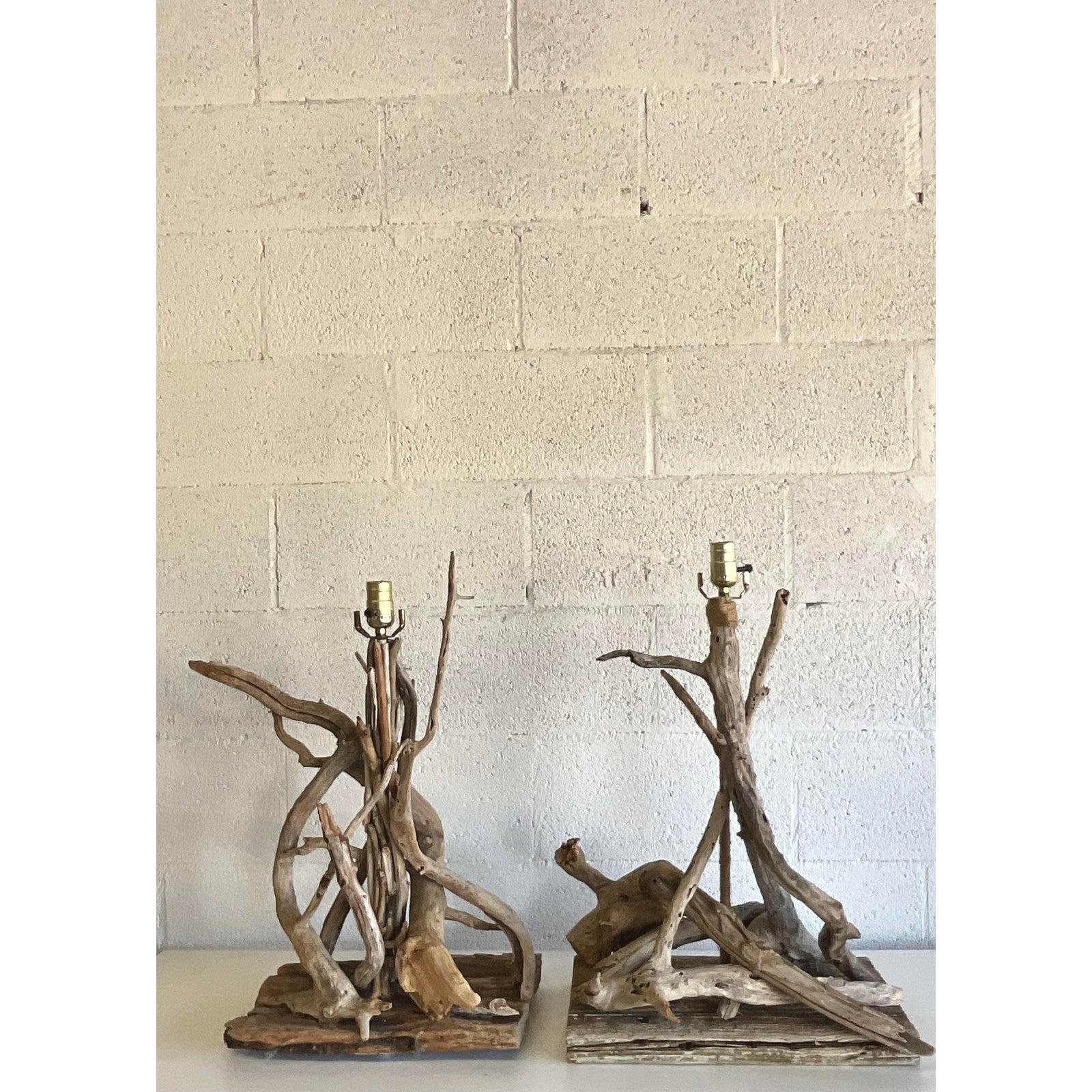 Fantastic pair of vintage driftwood lamps. A Brutalist approach with all the gnarly edges exposed. Rest on two mismatched, but harmonious plinths. Acquired from a Palm Beach estate.