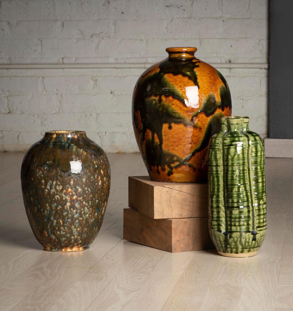 Pair of two midcentury drip-glaze ceramic vases with hallmark. Organic and expressive, these vases have an excellent color quality and richly dimensioned texture. The green vase is from 1960s Japan and the brown vase is from 1960s Austria. They