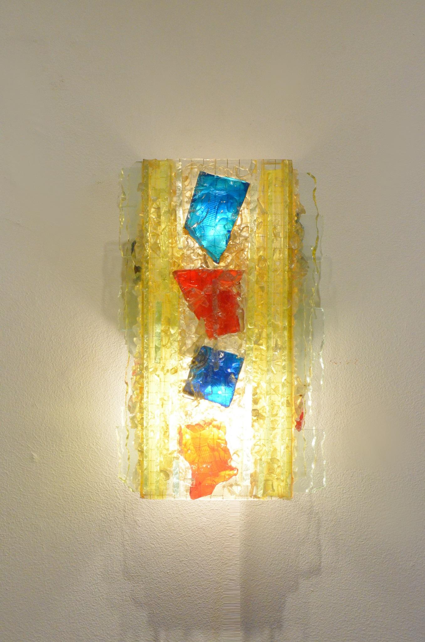 Decorative midcentury Raak wall sconce, multi-color thick armed glass structure matched with colored glass pieces.