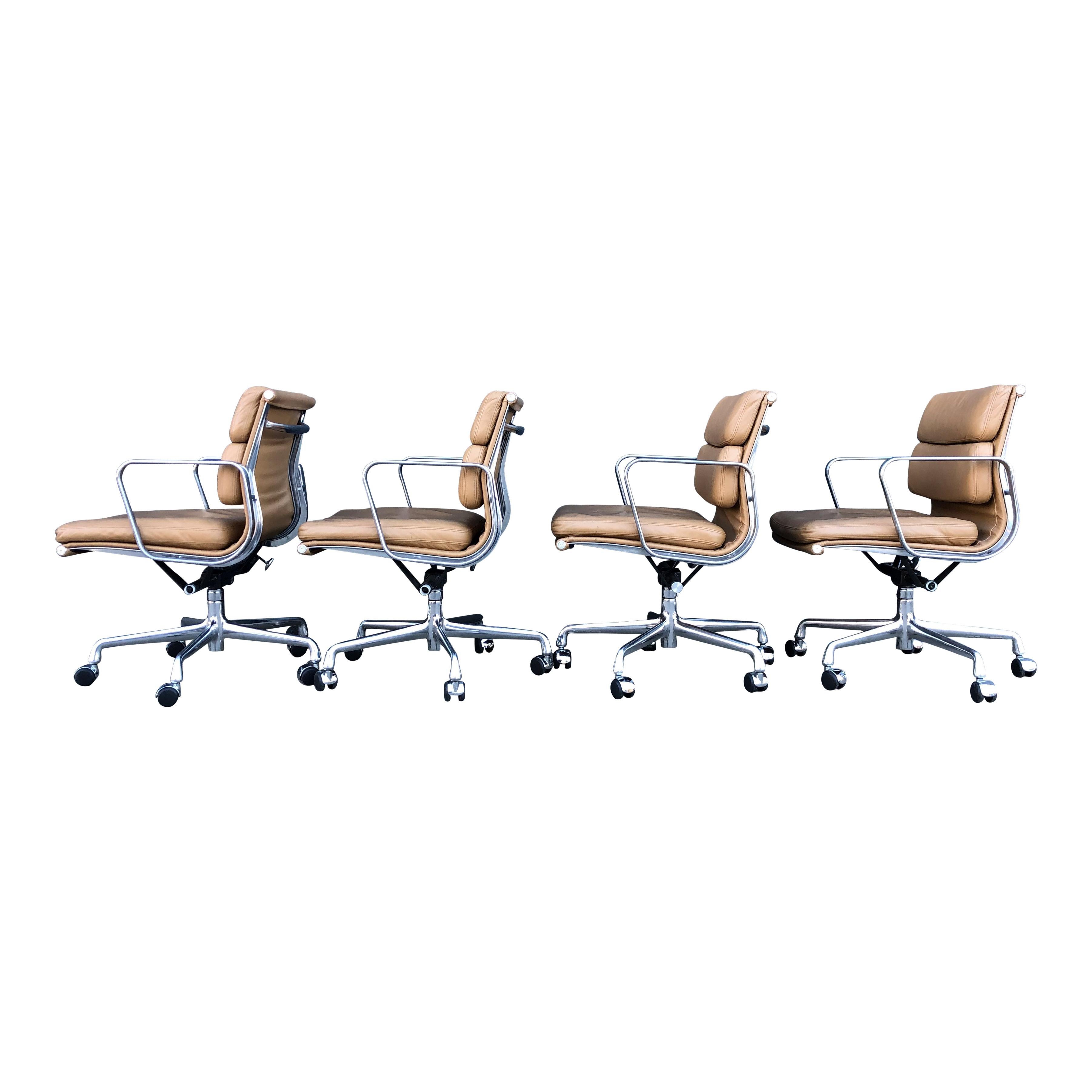 For your consideration at up to four authentic Eames for Herman Miller vintage soft pad chairs in brown leather with low backs. These authentic examples are icons of Mid-Century Modern design. The chairs, part of the Eames Aluminum group designed