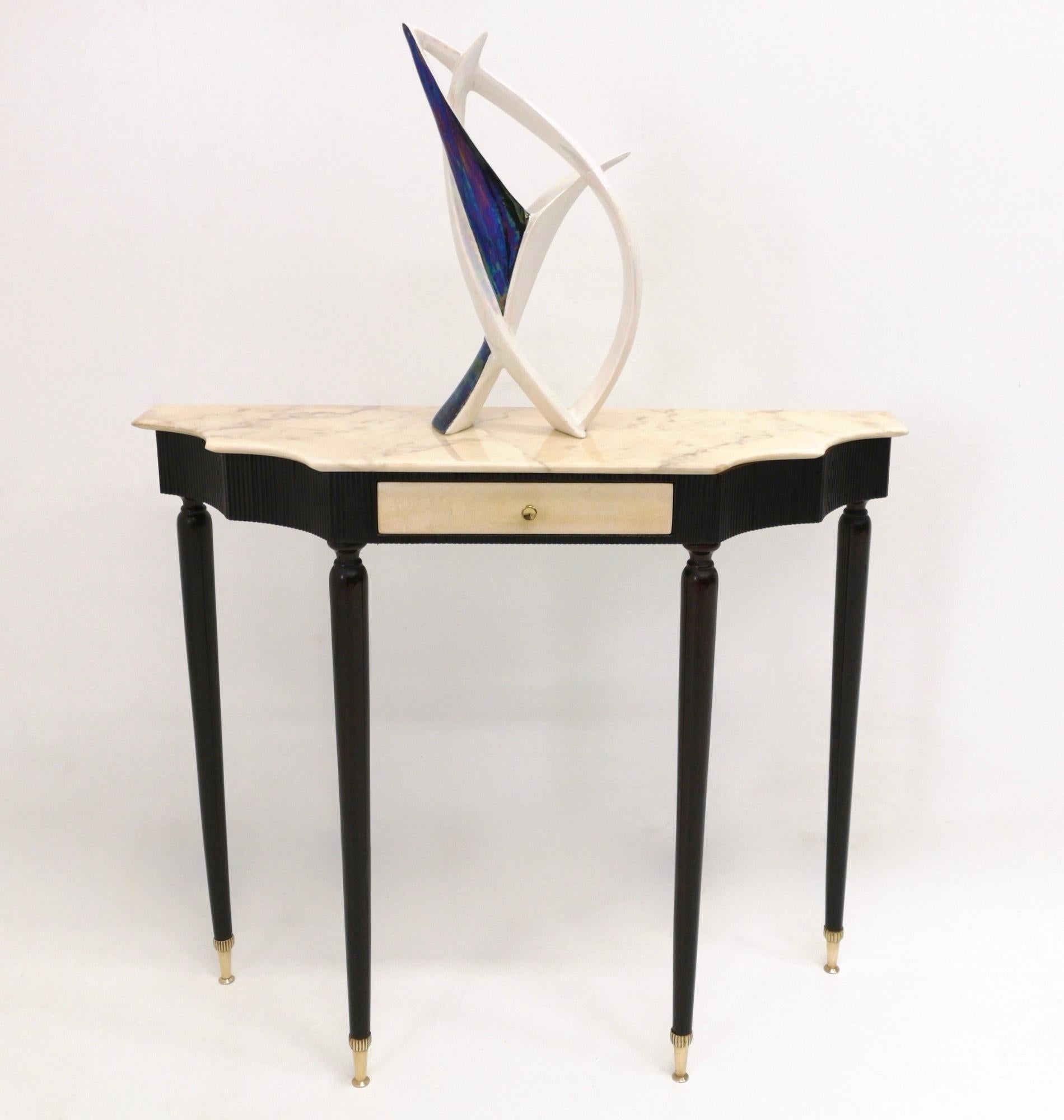 The frame is in ebonized wood. 
This console features a drawer, which is covered in parchment paper, brass handle and feet caps and a Portuguese pink marble top. 
It may show slight traces of use since it's vintage, but it can be considered as in