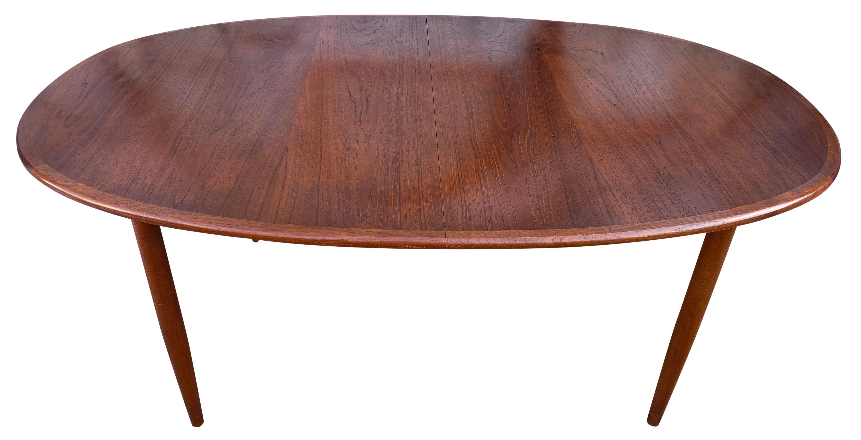 Midcentury teak elliptical oval Danish extension dining table with (3) leaves. This table is very high quality hand built in Denmark. Solid teak legs with 4 leg base. This table is in great vintage condition, the (3) leaves look rarely used and are