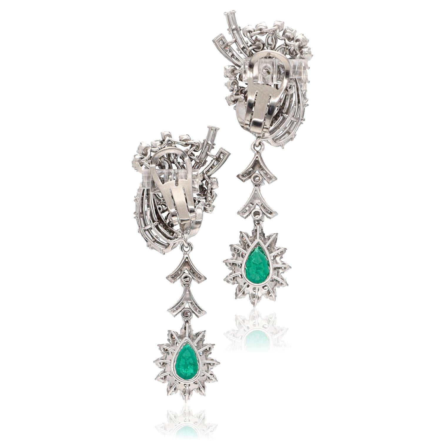 A stunning pair of Midcentury earrings from the 1950s, meticulously crafted in luxurious platinum. These earrings feature a captivating detachable drop, adorned with exquisite pear-shaped emeralds that glisten in deep shades of green. Surrounding