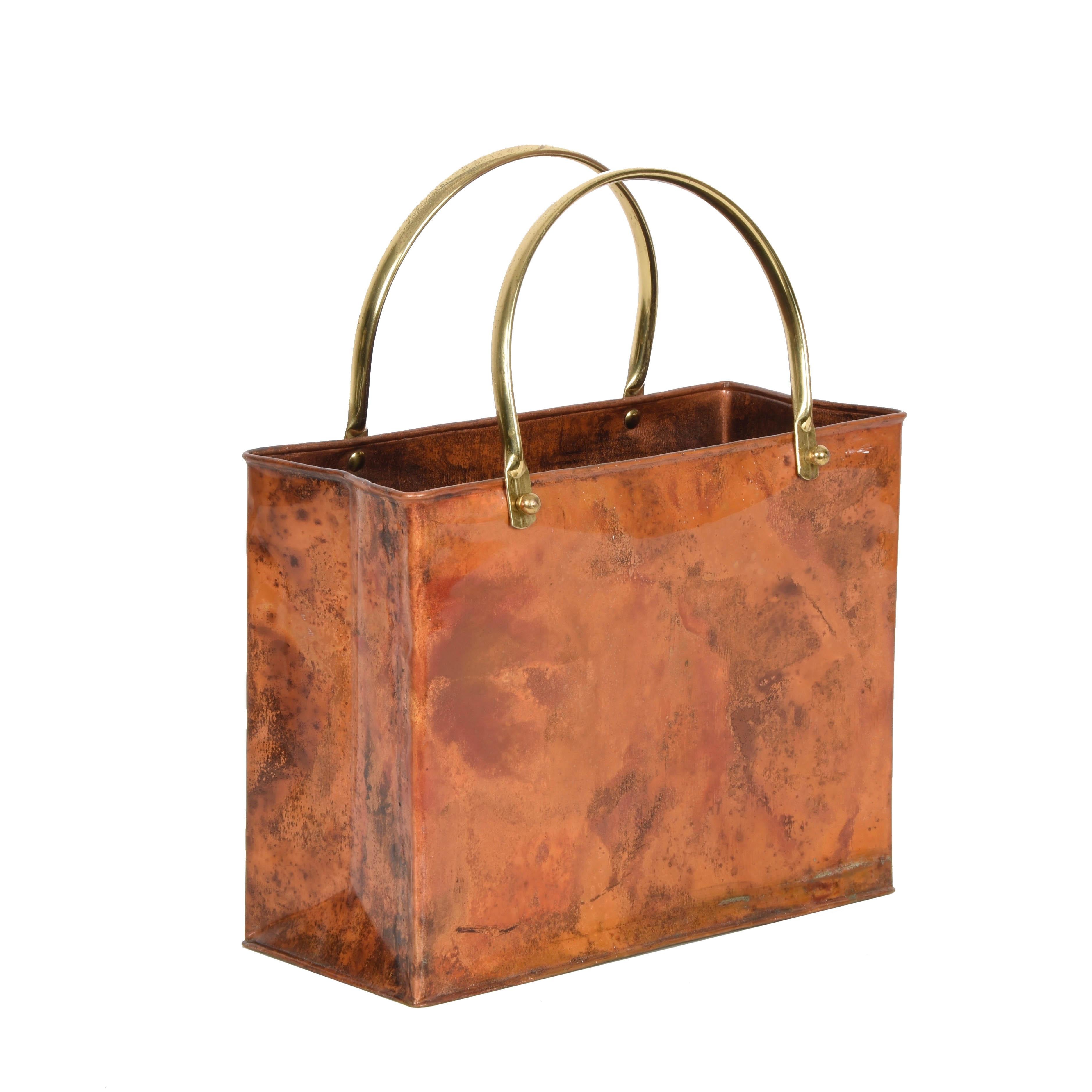 Midcentury enameled copper magazine rack with brass handles. This wonderful piece was designed in Italy during the 1970s.

This item is astonishing because of the contrast between the materials and the shape. In fact, a Classic midcentury shopping