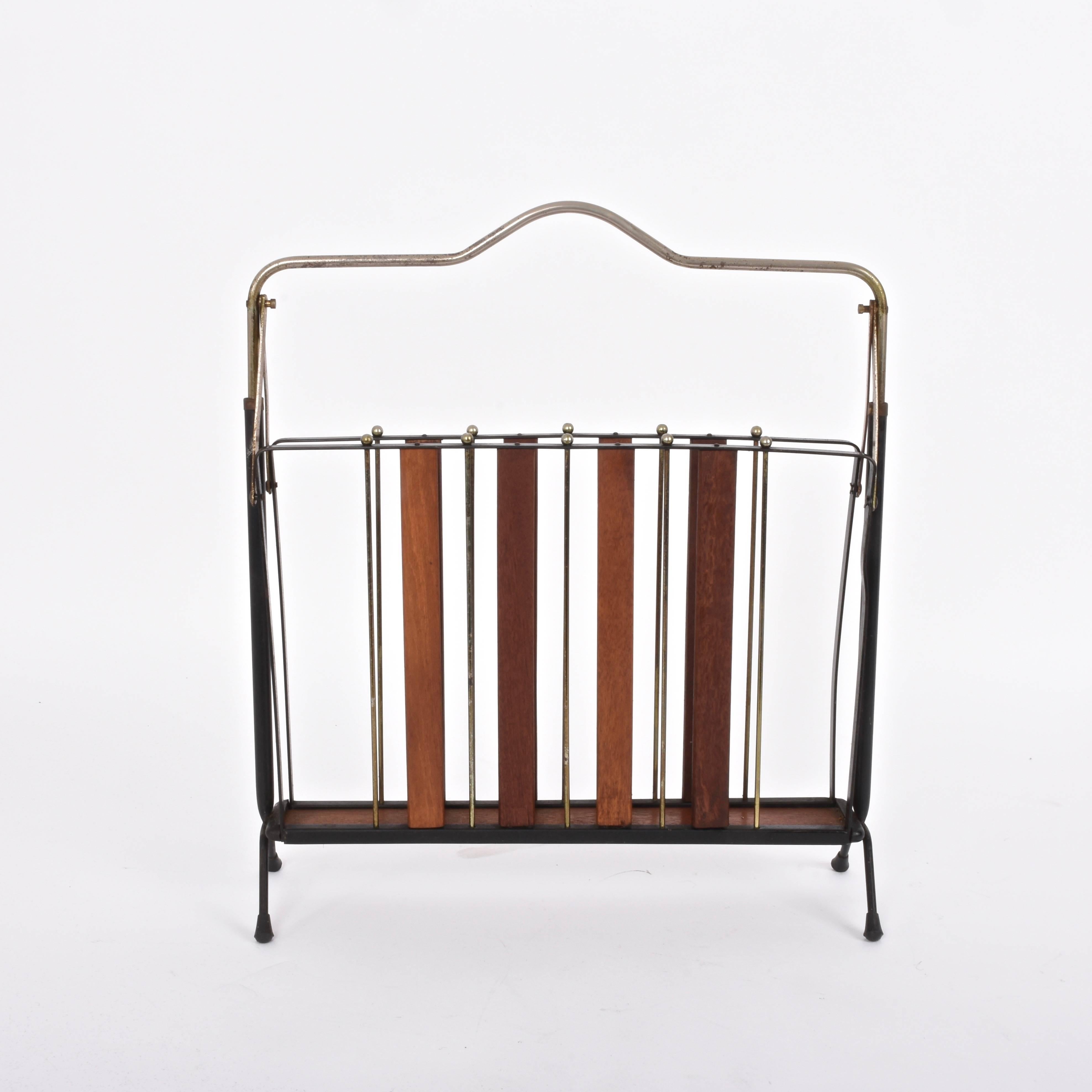Beautiful and unique magazine rack in metal and wood produced in Italy, circa 1950s.

A wonderful enamelled metal, wood and brass piece, that will enrich a living room or a wooden library.