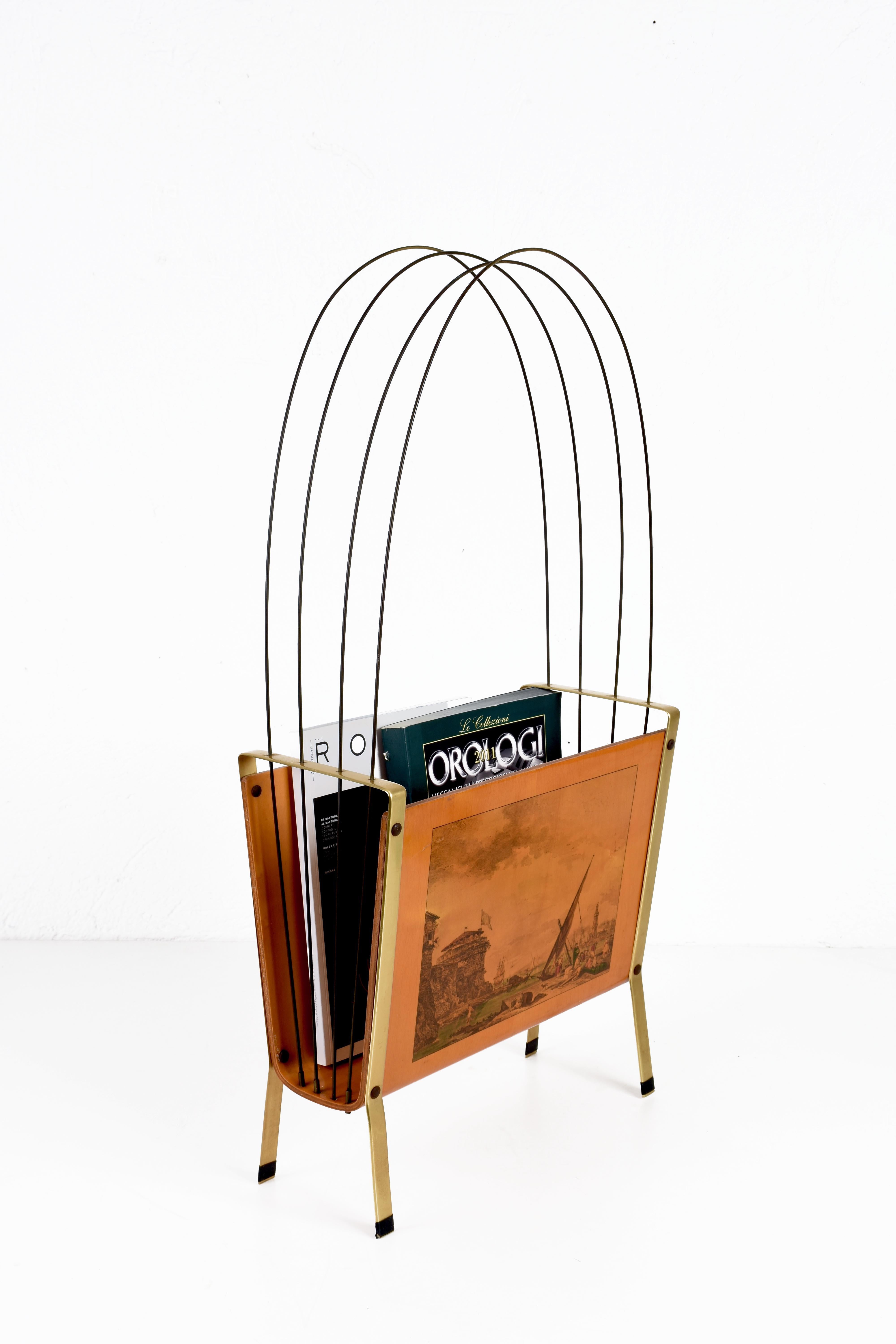Amazing midcentury enameled metal, maple, teak and brass magazine rack. This unique piece was produced in Italy during 1950s.

This item is breathtaking has its structure is made of multiple layers of teak and maple wood, with curved solid brass