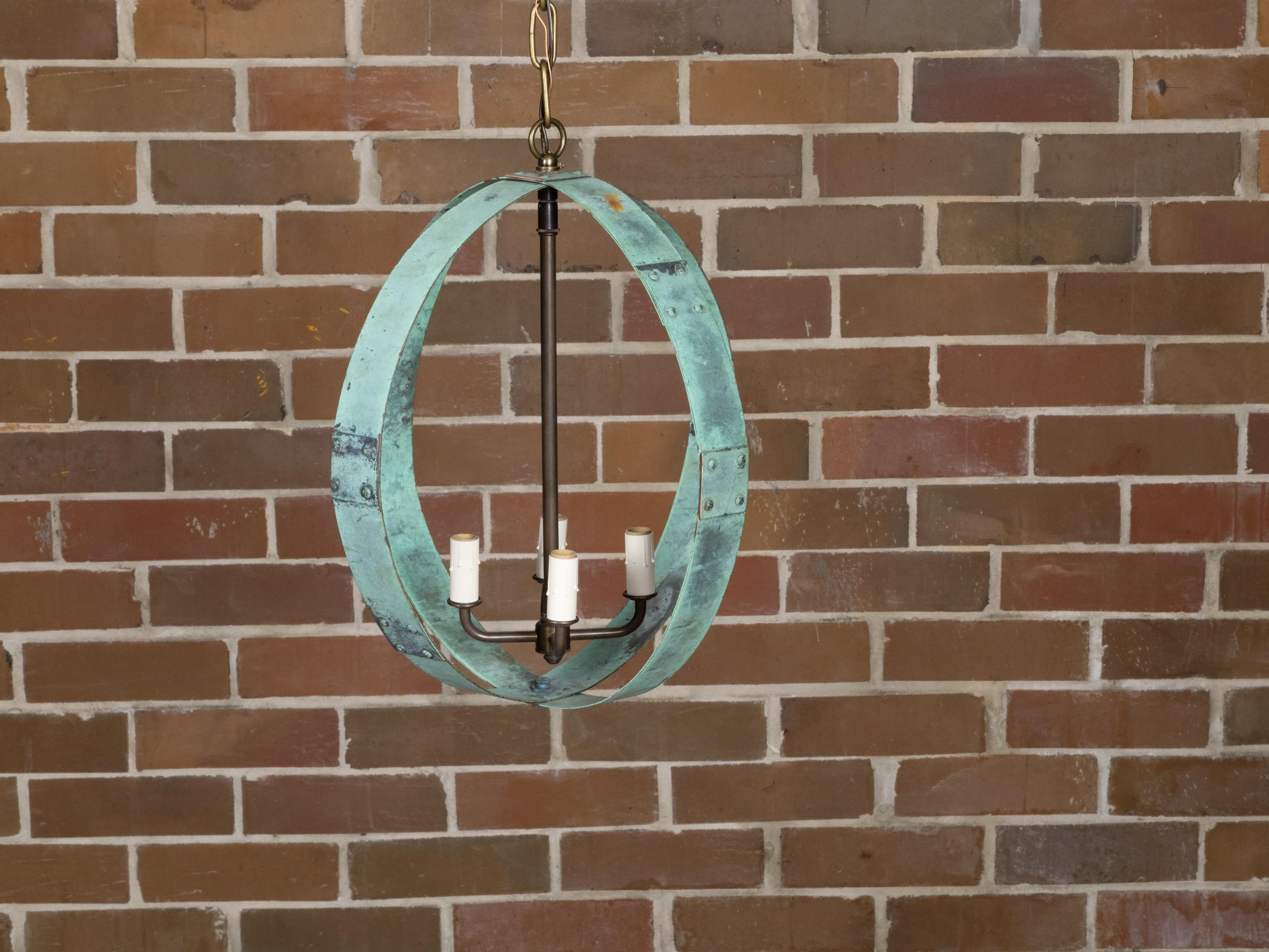 Apparecchio di illuminazione a doppio anello in rame inglese del Midcentury con quattro luci e patina verdastra, ricablato professionalmente per gli Stati Uniti. Creata nell'Inghilterra della metà del XX secolo, questa squisita lampada a doppio