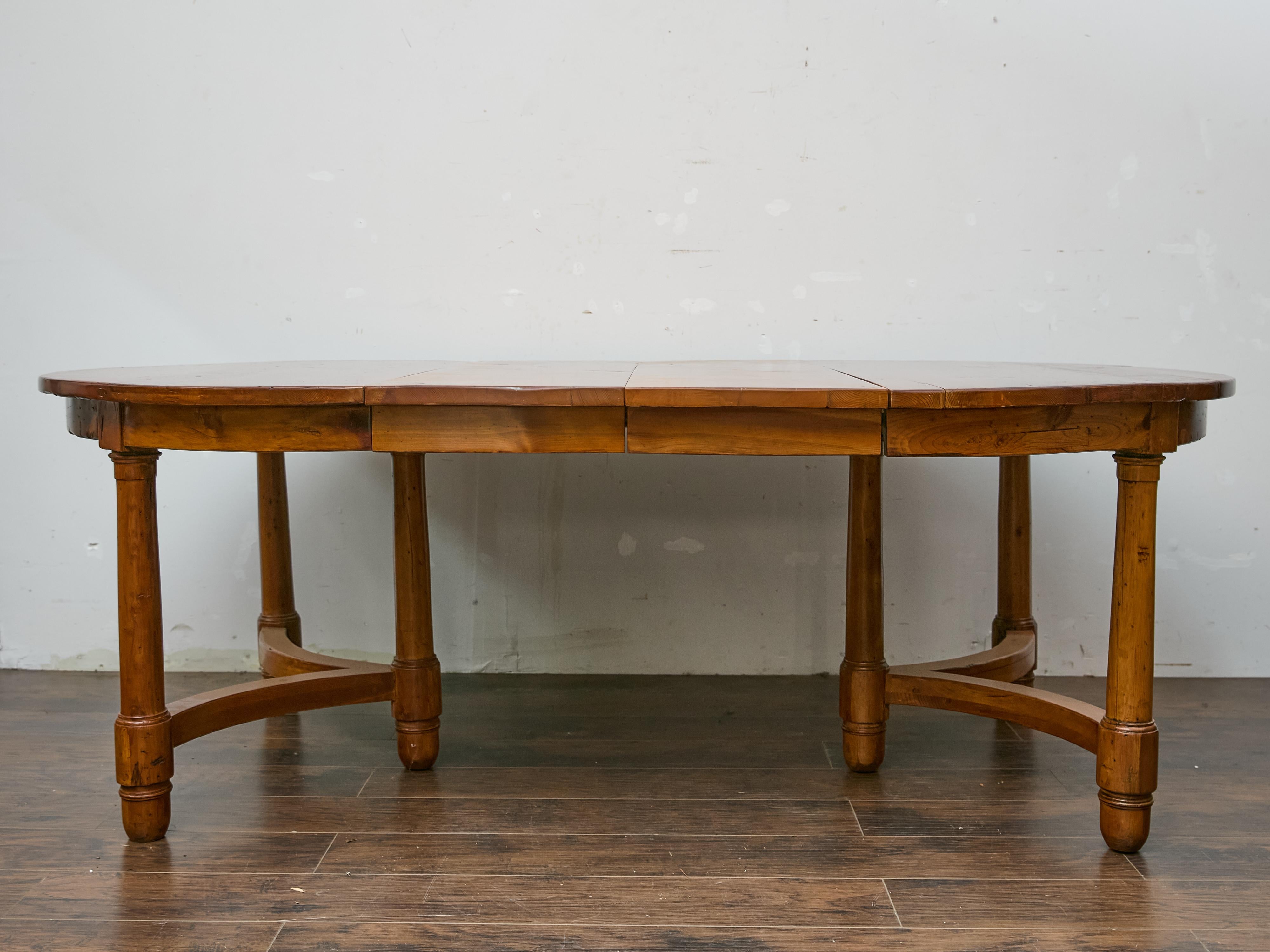Una versátil mesa de comedor inglesa de mediados de siglo en pino macizo, que ofrece una presencia cálida y acogedora. Diseñada pensando en la adaptabilidad, esta mesa extensible pasa sin esfuerzo de un tablero redondo de 55,5 pulgadas a una amplia