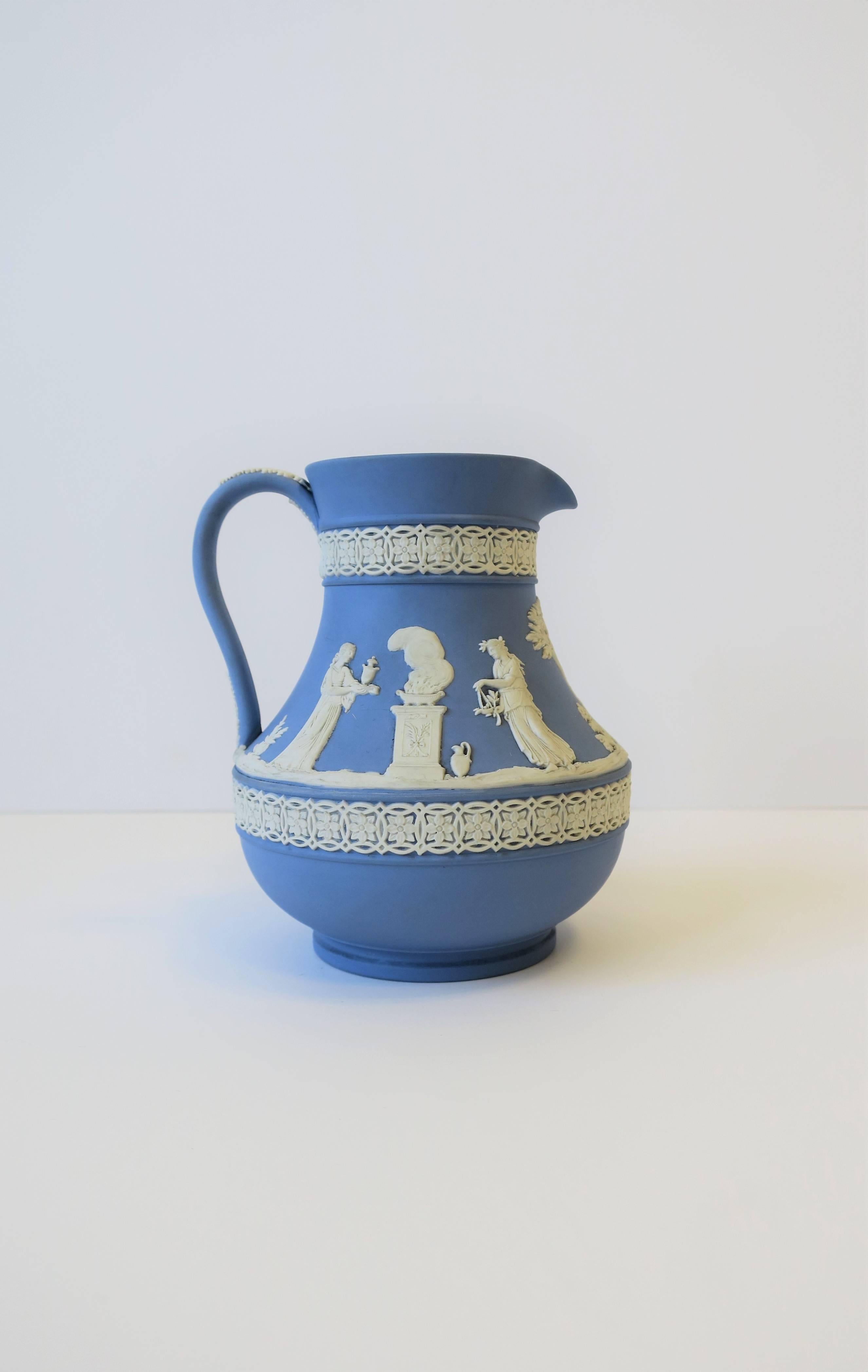 A beautiful mid-20th century English Wedgwood blue and white jasperware pitcher in the neoclassical style, 1951, England. A beautiful raised white relief around pitcher/vessel. Maker's mark and other markings on bottom as show in image #10.