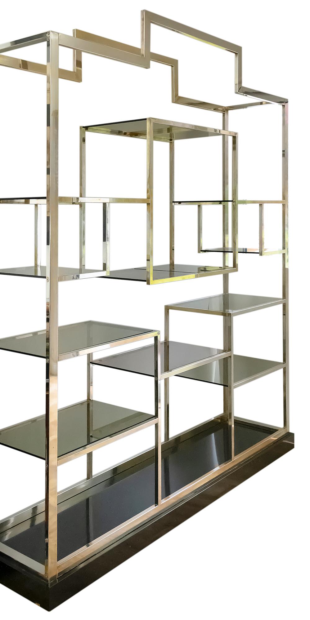 Midcentury brass étagère/shelves by Kim Moltzer from 1970s.
The shelves structure in square brass plated metal with shelves in smoky glass on black wood base.