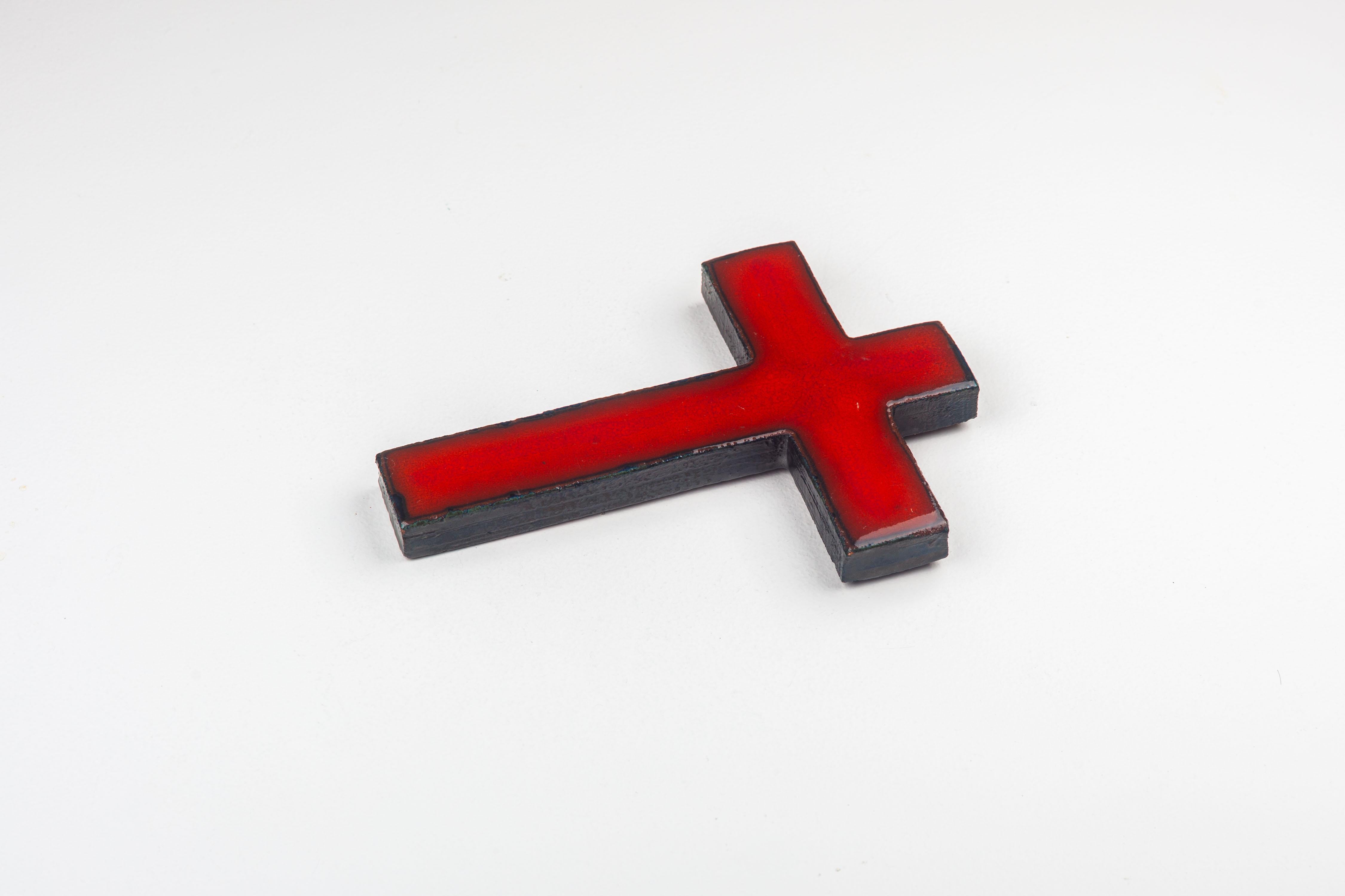 This mid-century modern ceramic cross is a great example of post-war European studio pottery, an art form that embraced both functional and abstract aesthetic principles. The handcrafted piece stands out for its rich, cardinal red glaze—a color