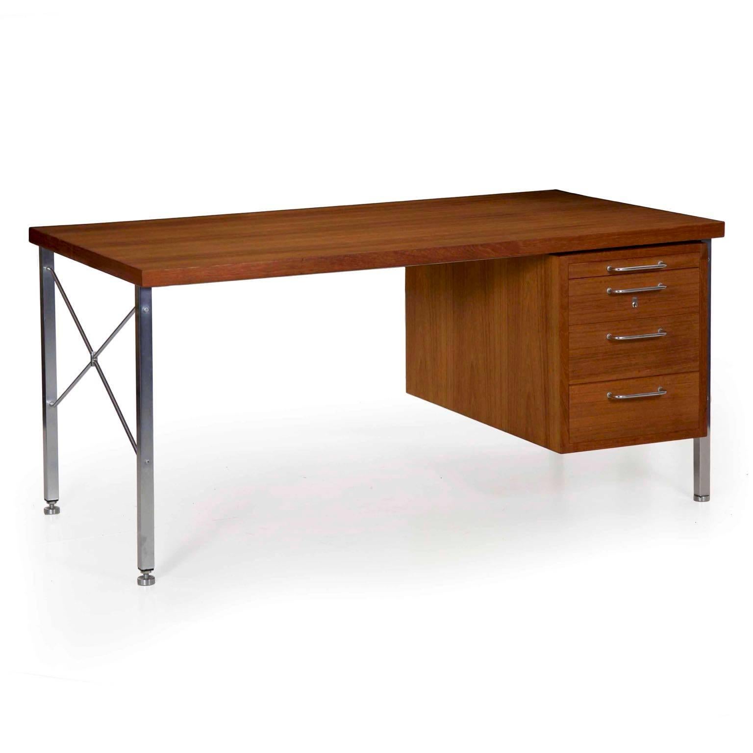 A very precisely built Mid-Century Modern executive desk designed by Hans Wegner and produced in Denmark by Johannes Hansen, this vintage desk is crafted of teak veneers and teak solid over oak, pine and MDF against brushed stainless steel and