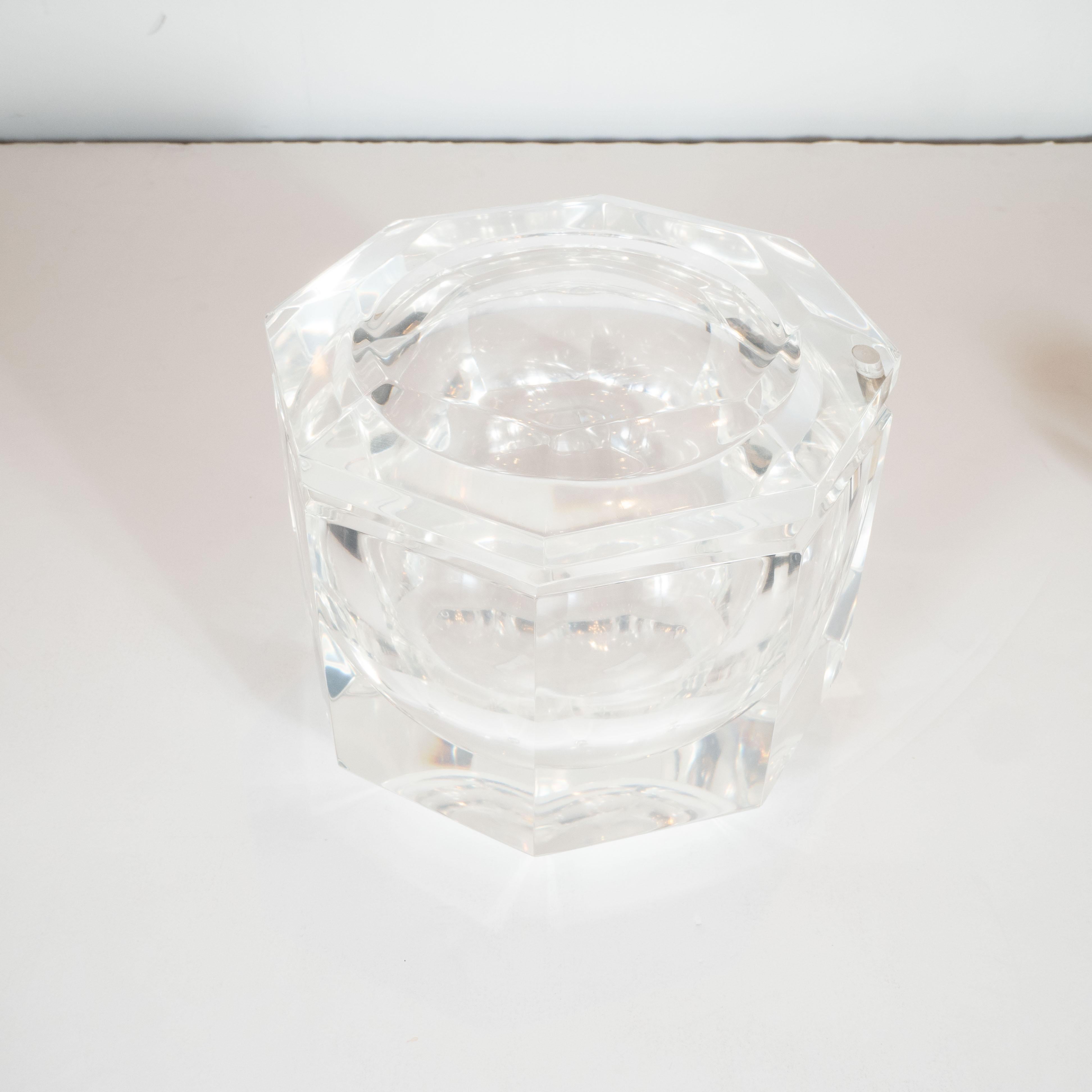 This elegant Mid-Century Modern octagonal ice bucket was realized in the United States by the esteemed designer Carol Stupell, circa 1970. It features a faceted body and top composed of faceted translucent Lucite, giving it the overall appearance of