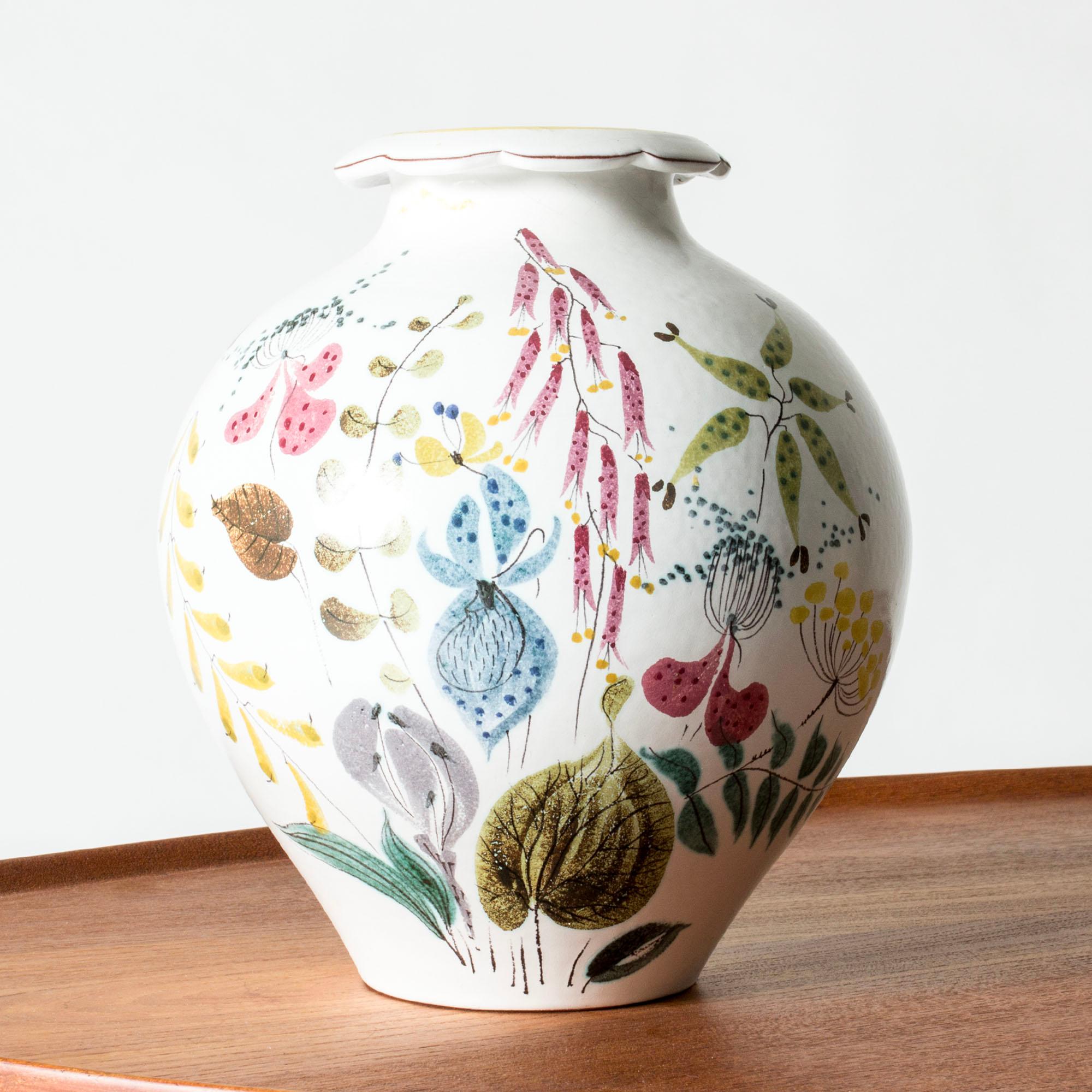 Bellissimo vaso in maiolica di Stig Lindberg dalla forma ampia. Decorazioni vivaci e colorate con una varietà di fiori e foglie.