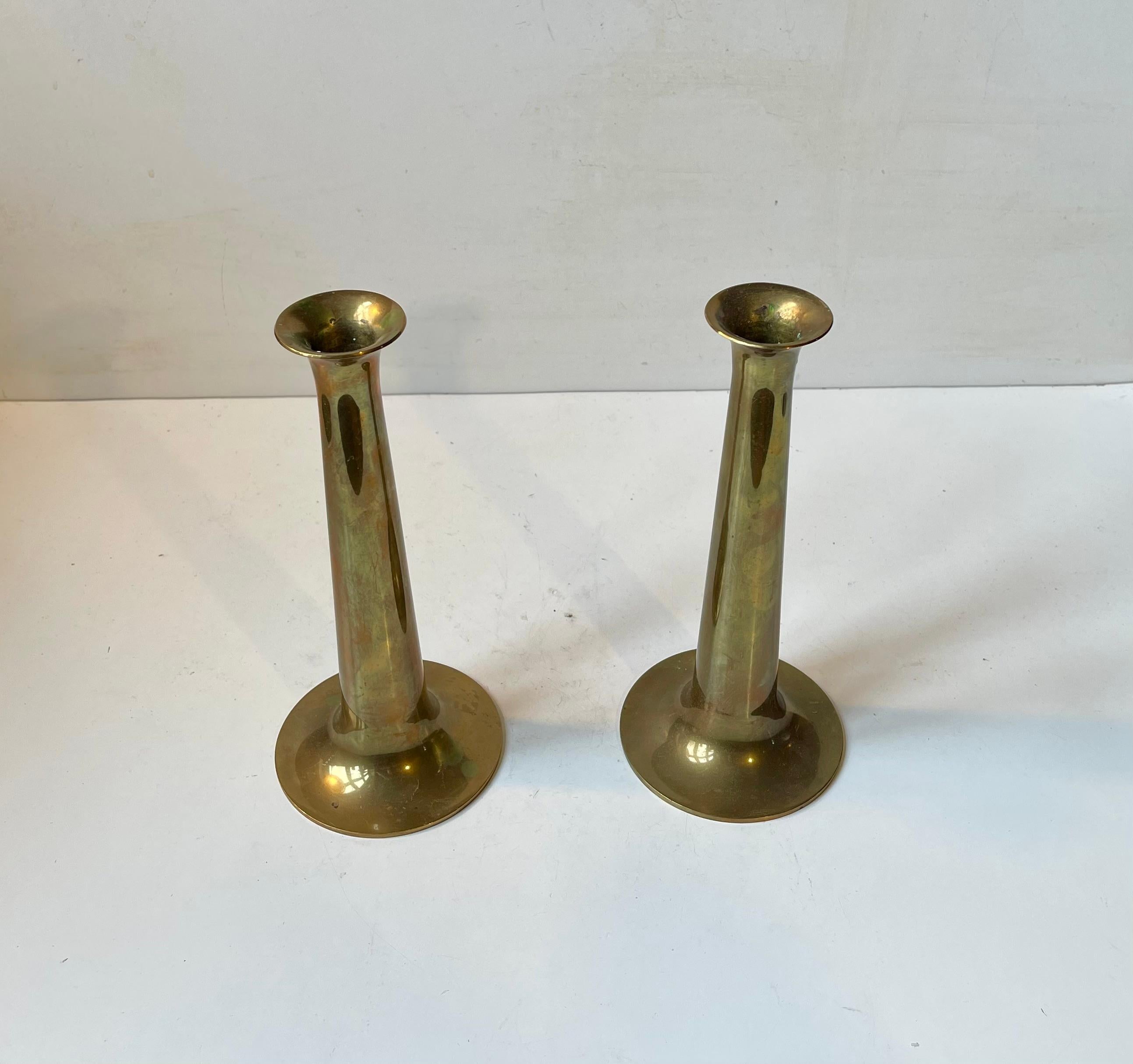 This pair of candlesticks was designed by Hans Bølling and manufactured by Torben Orskov in Denmark during the 1950s. They are called Fanfare or trumpet and are made from solid brass featuring the manufacturer's mark to each base. For regularized