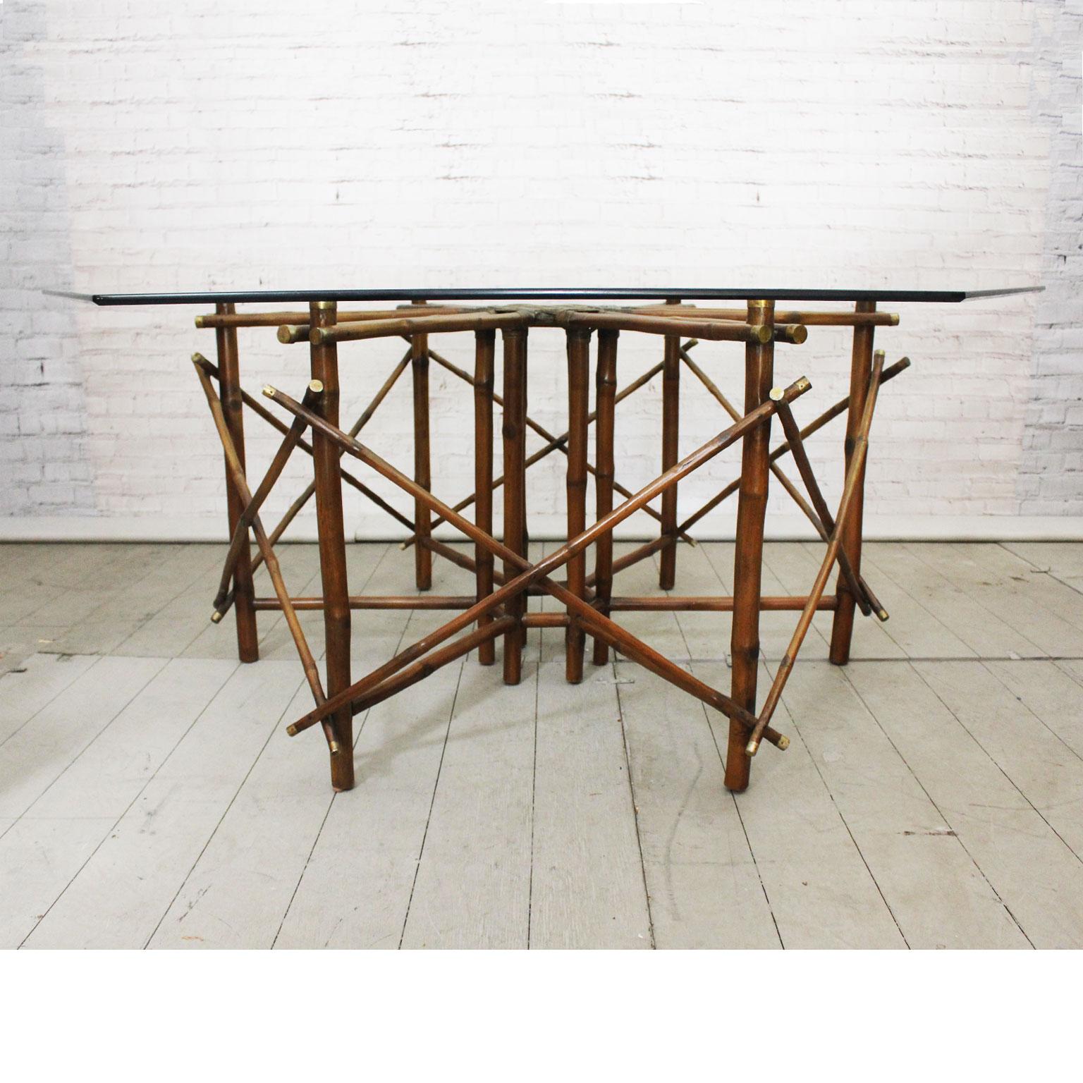 We believe this superb 1960s table was a one-off commission designed by John Wisner for Ficks Reed. We have been unable to find another example anywhere. The brass capped bamboo base is finished with a woven leather centre piece. The heavy, bevelled