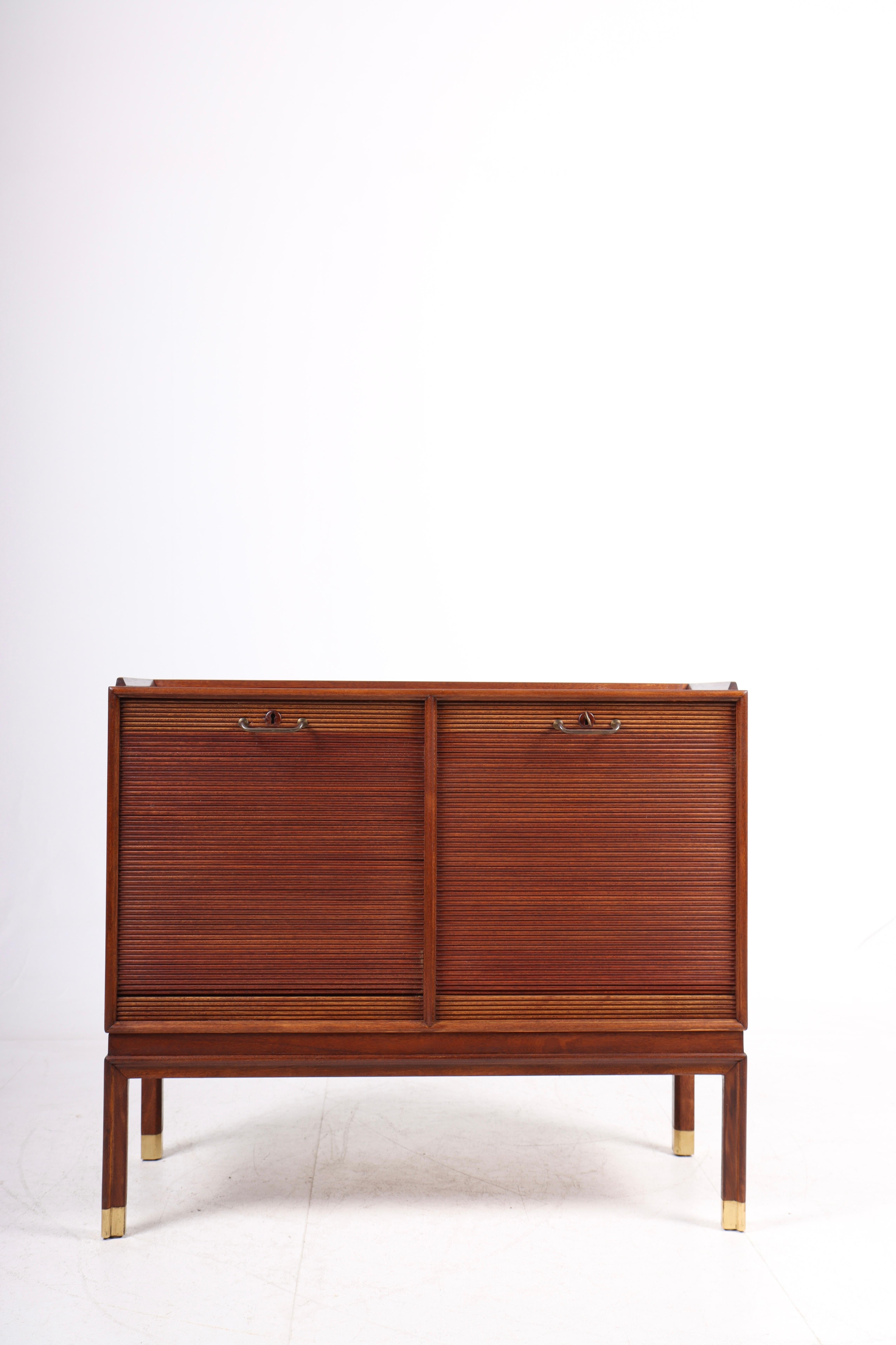 Cabinet in mahogni with tambour doors and brass shoes. Designed and made by a Danish cabinetmaker. Great condition.