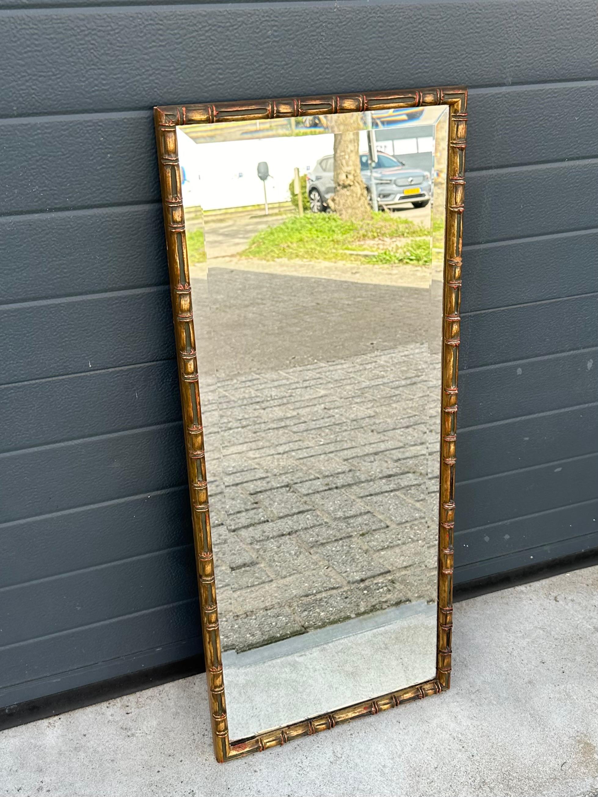 Striking Italian faux bamboo hand carved frame with a thick beveled mirror.

Via one of our foreign contacts we recently purchased this practical and handcrafted wall mirror from the midcentury modern era. The all hand-carved wooden frame is in a
