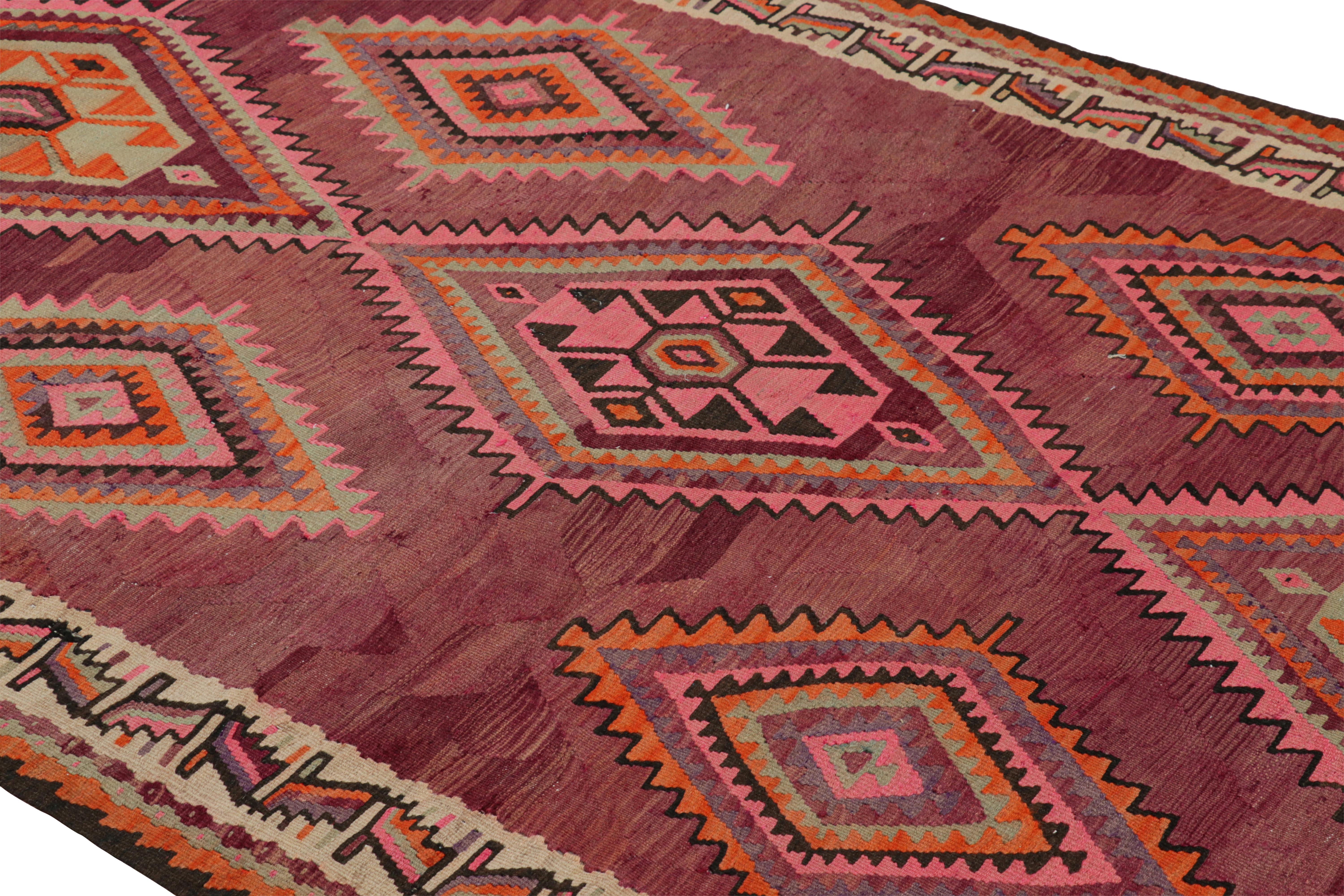 Dieser handgewebte Wollteppich aus der Mitte des Jahrhunderts (ca. 1950-1960) zeigt geometrische Stammesmuster in Rot, Grün, Orange, Rosa und Schwarz, die über den gesamten Teppich verteilt sind. Die traditionellen Medaillonmuster dieses alten