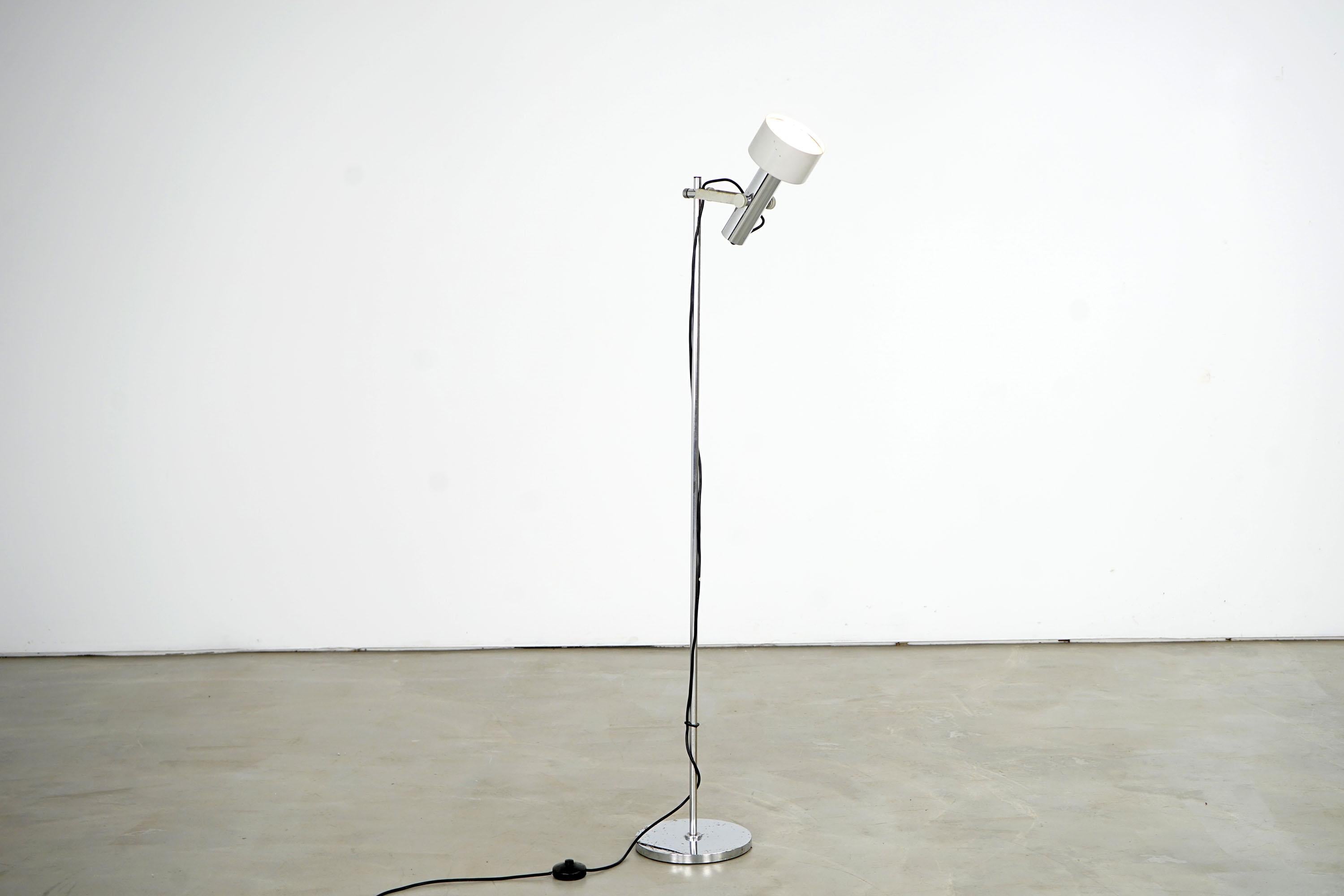 The floor lamp dates back to the 1970s. Stylistically, it is assigned to the midcentury. The piece is made of steel, individual elements were chrome plated. The floor lamp is height adjustable, the shade can be flexibly swiveled. The lamp is in very