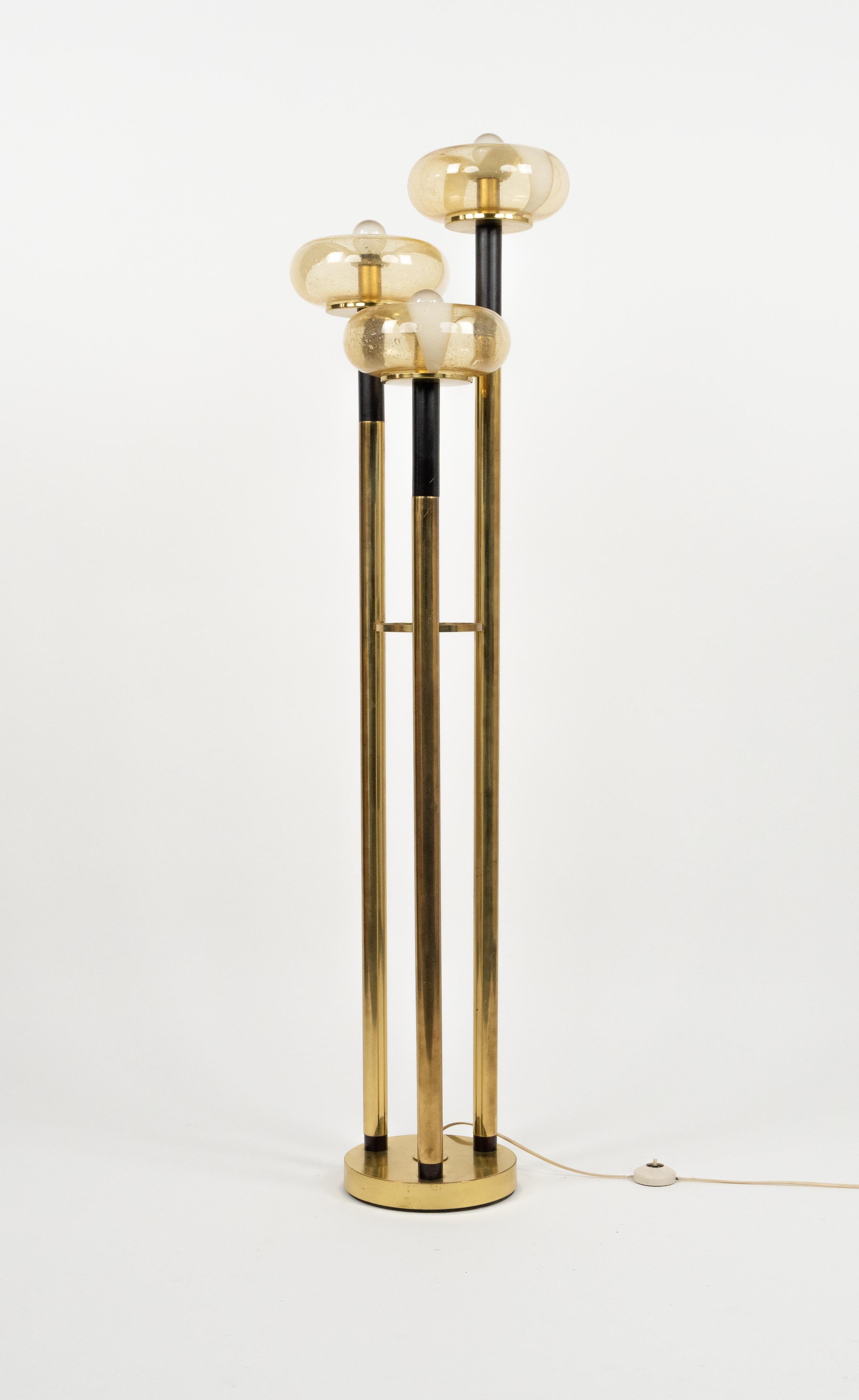 Midcentury amazing floor lamp with brass three tubular supports, each holding a murano-glass in the style of Mazzega.

Made in Italy in the 1970s.

It uses 3 bulbs.

A beautiful lamp that is perfectly working but most of all, it provides an amazing