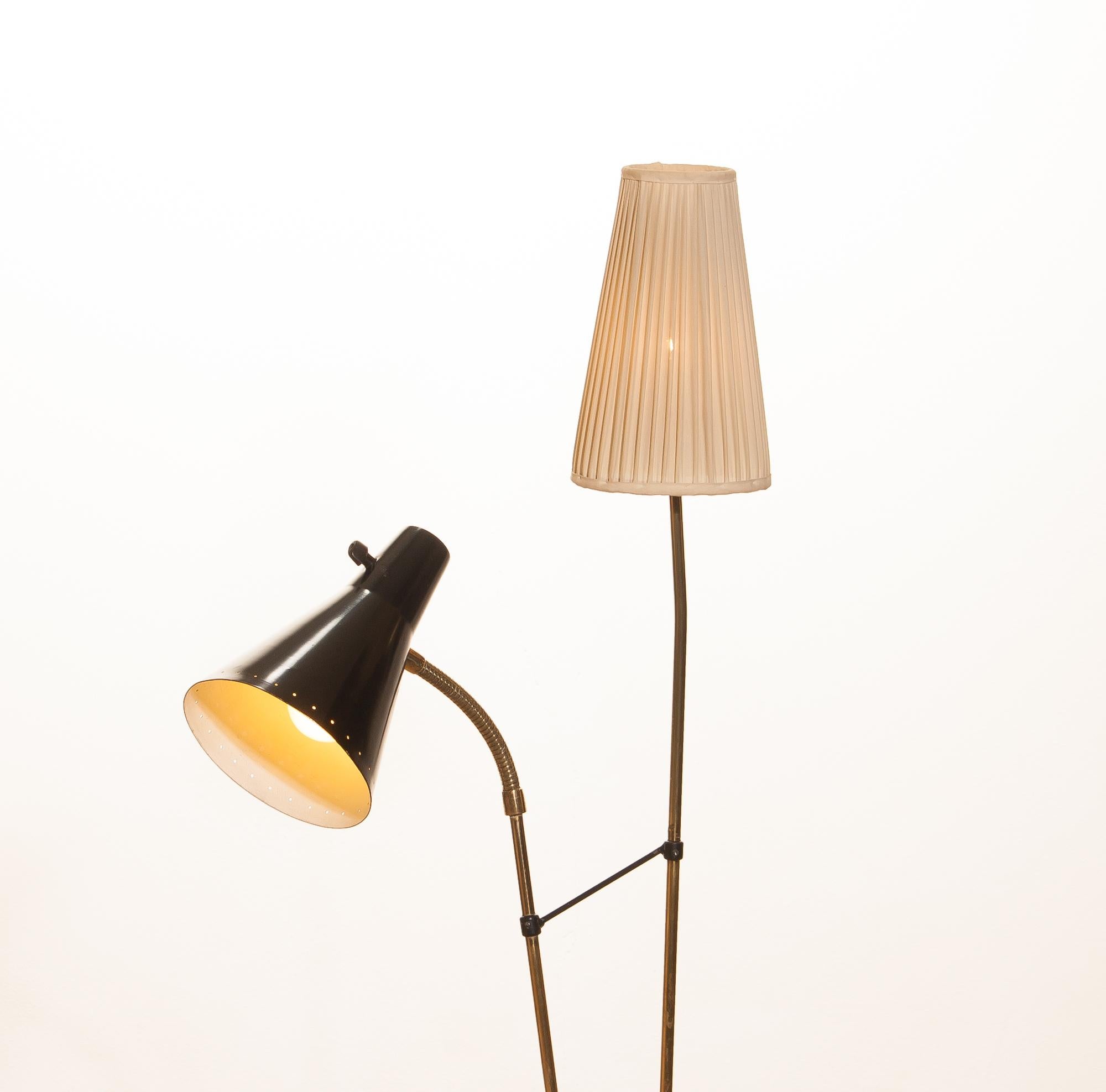 Beautiful floor lamp designed by Hans Bergström for Ateljé Lyktan, Sweden.
This lamp consists of two different shades; one black lacquered metal and one off-white fabric. The stand is made of brass with a beautiful rare foot. It is in a very nice