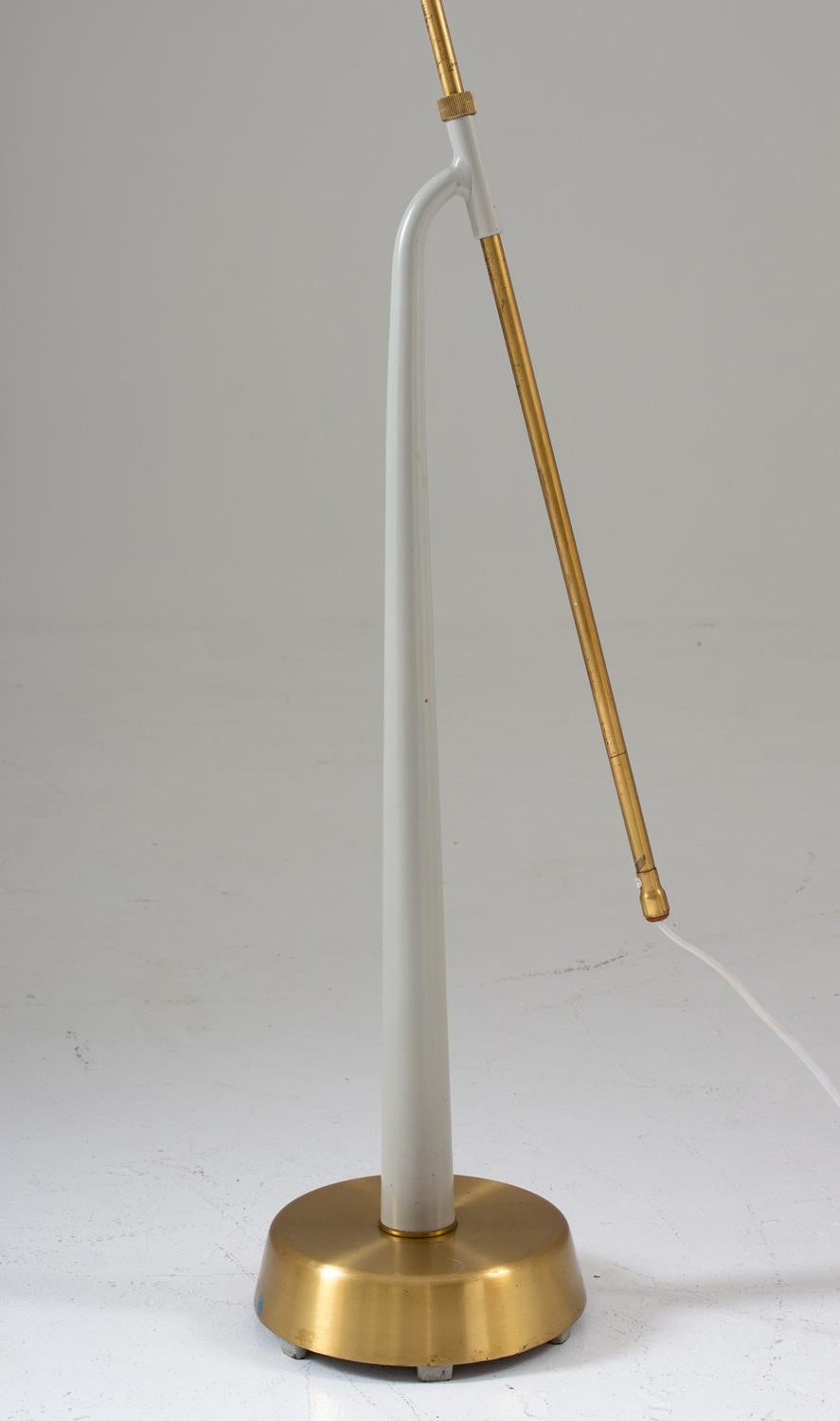 Lovely floor lamp model 541 in brass and metal by Hans Bergström for Swedish manufacturer Ateljé Lyktan. 
The lamp consists of a brass and grey metal base, supporting a brass rod that is adjustable in height. 
Maximum height is 165cm