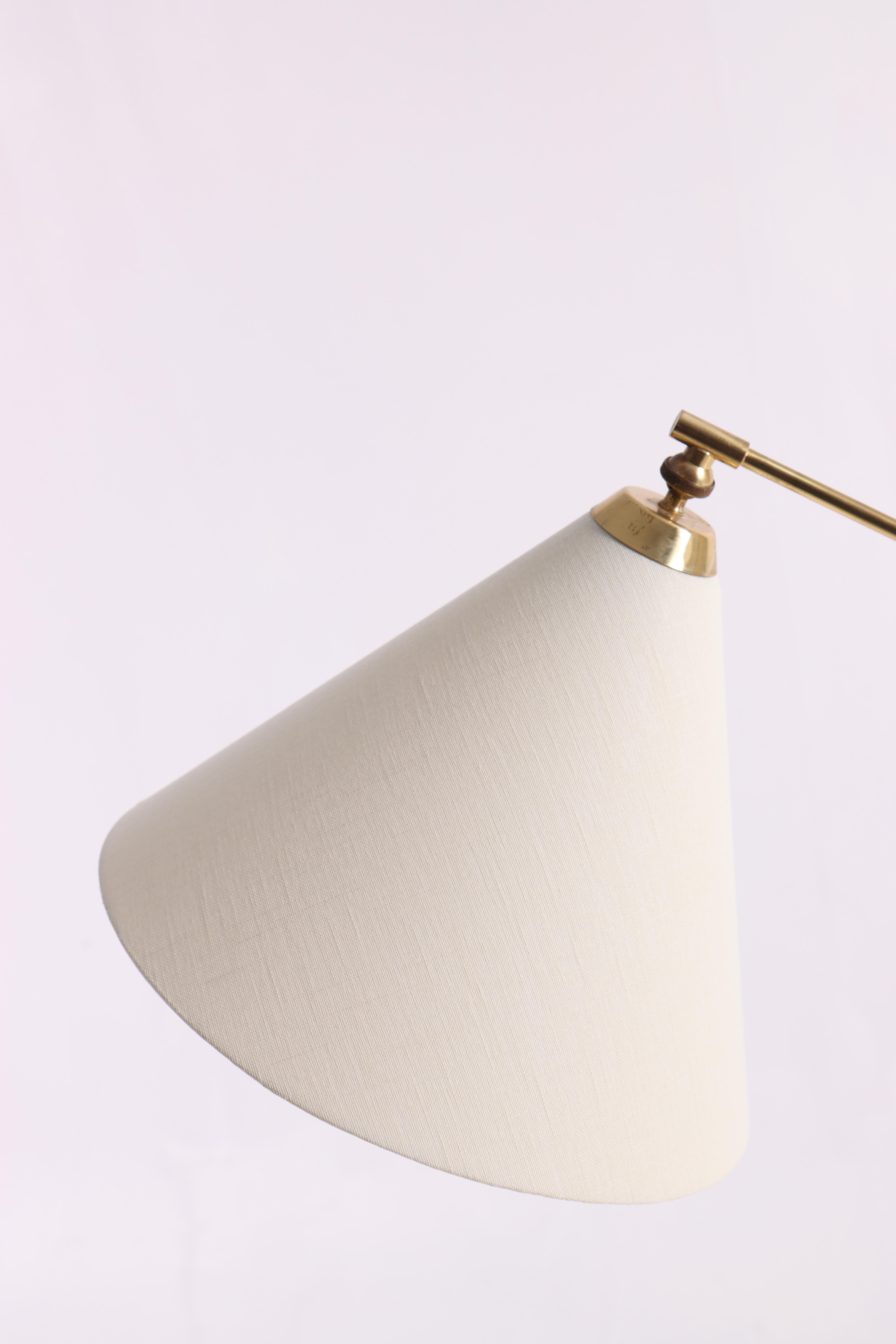 Adjustable floor lamp in brass. Designed by Th. Valentiner made by Poul Dinesen in 1950s. Made in Denmark. Comes with a new lampshade.
