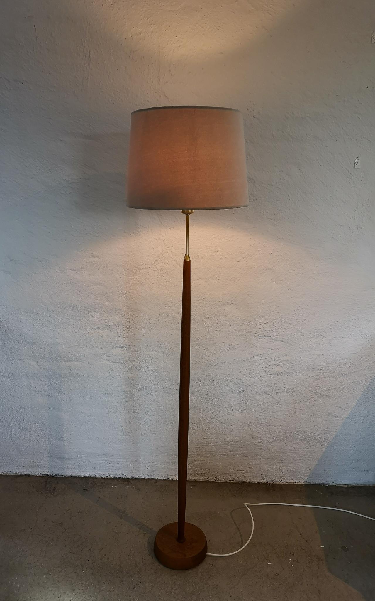 Cette lampe a été fabriquée en Suède par Falkenbergs Belysning. La combinaison du laiton et du teck fait de cette lampe une belle édition pour n'importe quelle pièce.

Bon état de fonctionnement. L'abat-jour en velours n'est pas d'origine c'est un