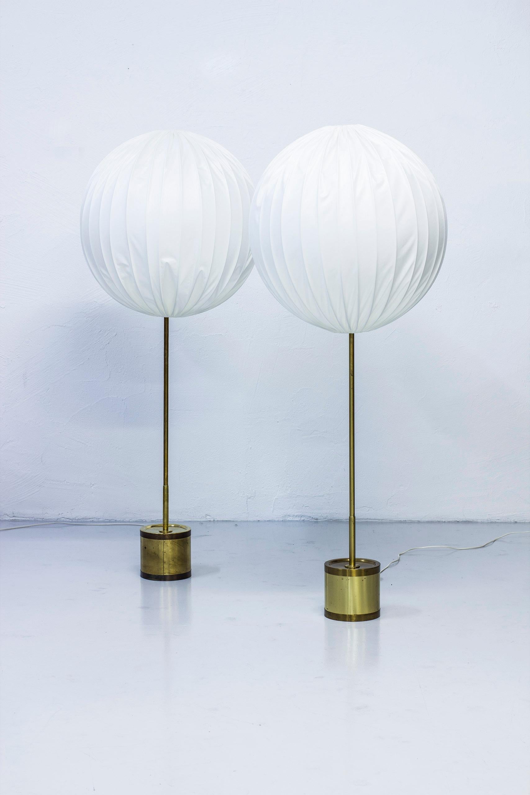 Floor lamp model G123/600 designed by Hans Agne Jakobsson. Produced by his own company in Markaryd, Sweden during the 1960s. Made from solid polished brass with original large round shades. Reupholstered in off white chintz fabric. Light switch on
